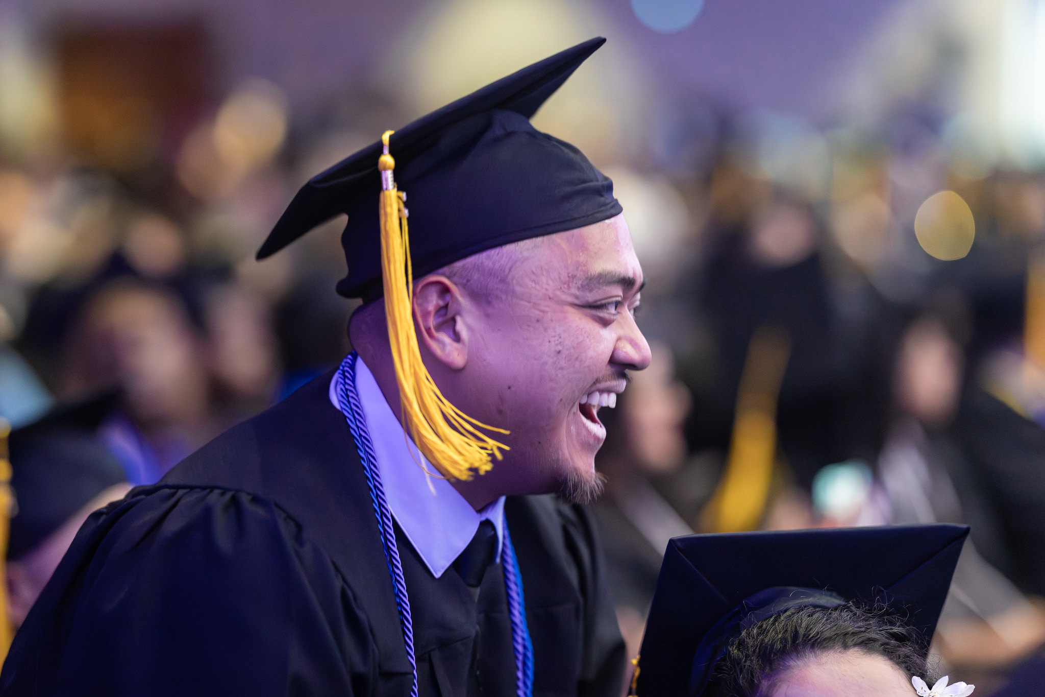 A smiling graduate in the audience.&nbsp;