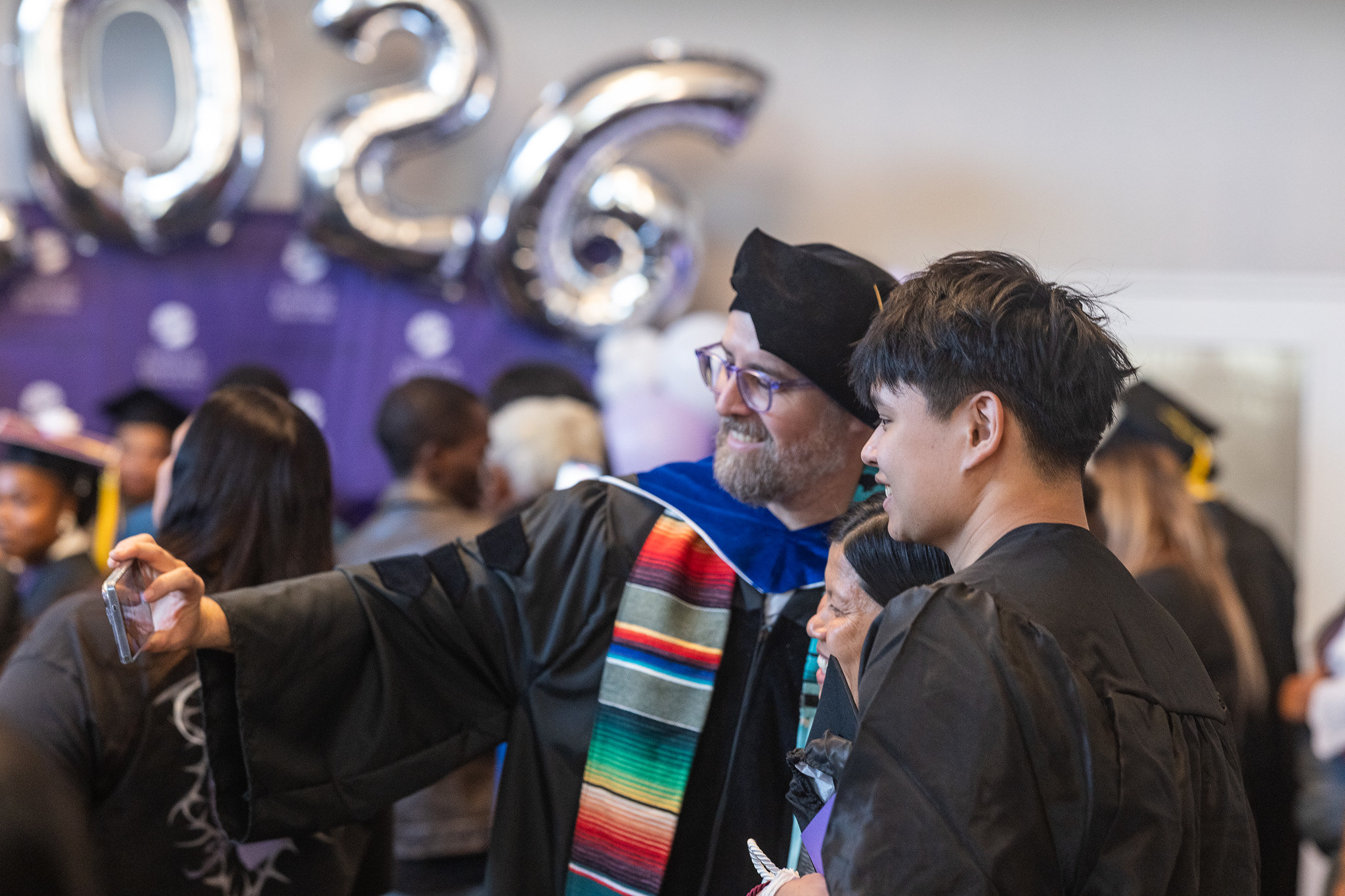 A graduate takes a selfie with his kids.&nbsp;