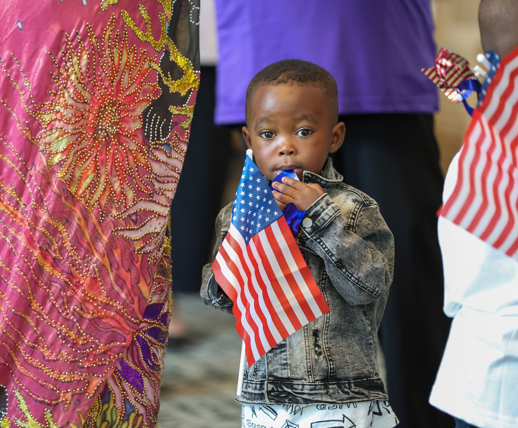 A toddler in the lobby is holding a small American flag.