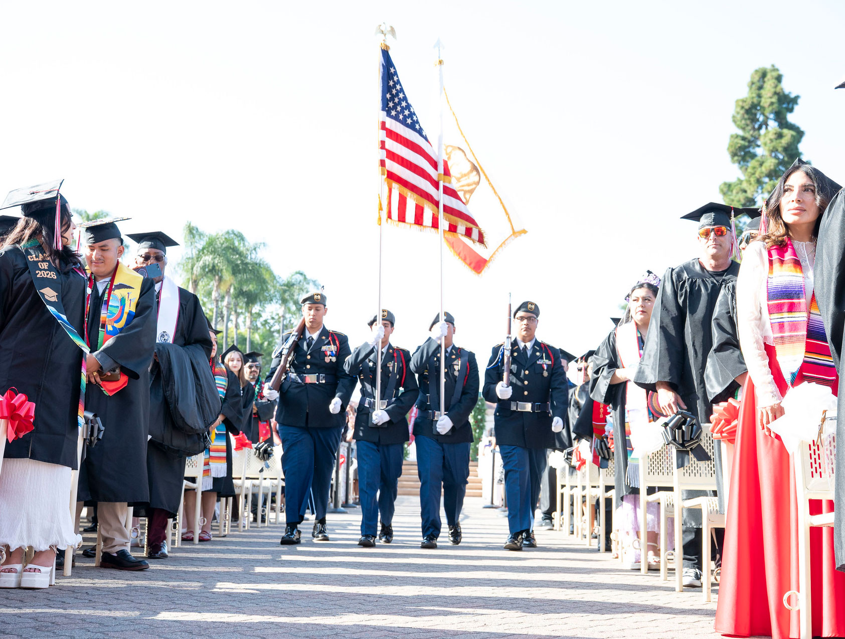 Four color guard members walk down the center aisle with the American flag at the beginning of the ceremony.
