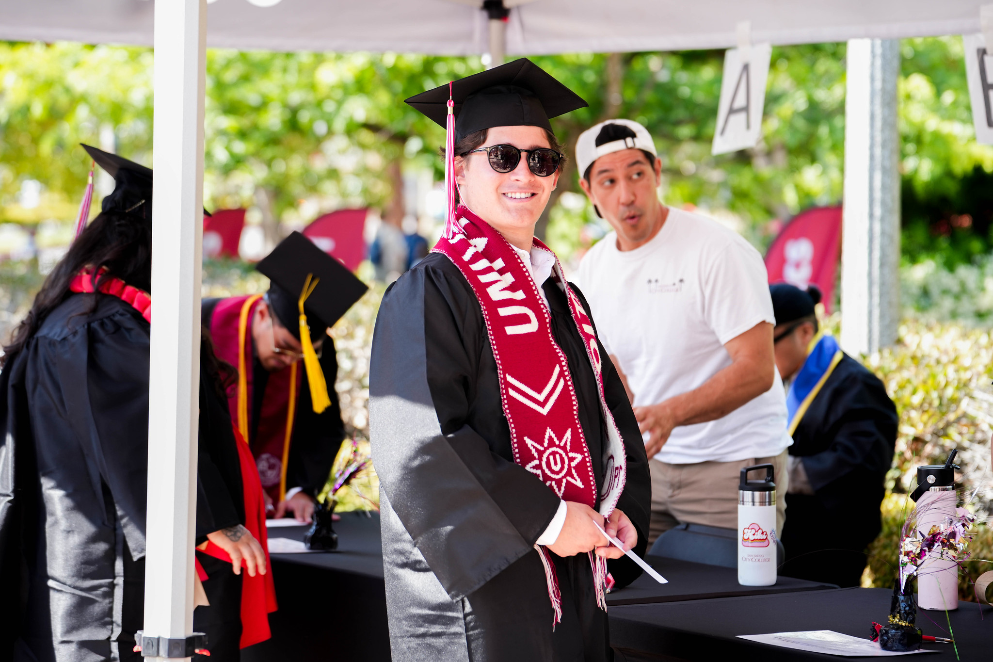 A graduate at a sign in table.&nbsp;