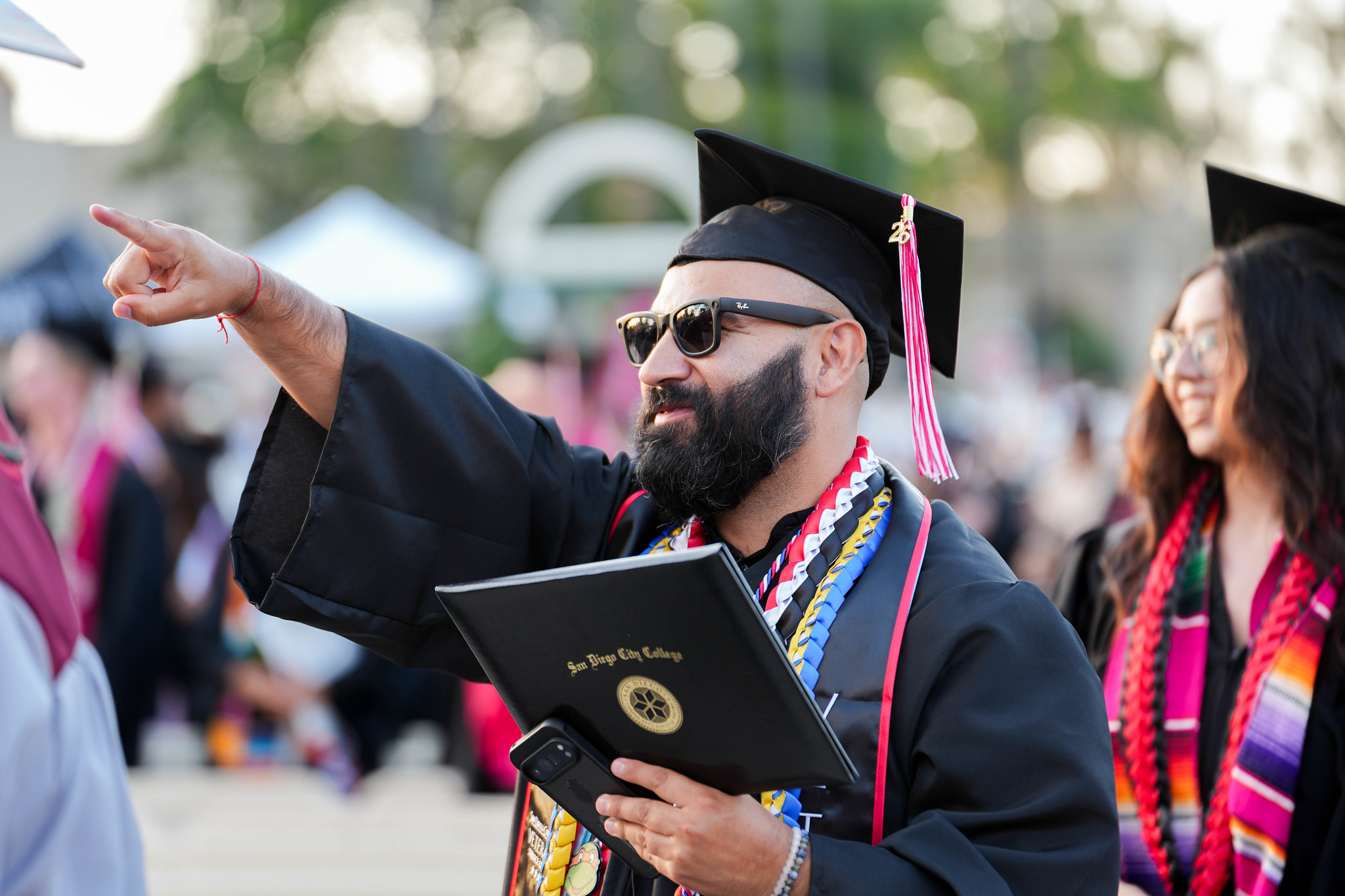 A graduate points to the audience after receiving his degree.&nbsp;