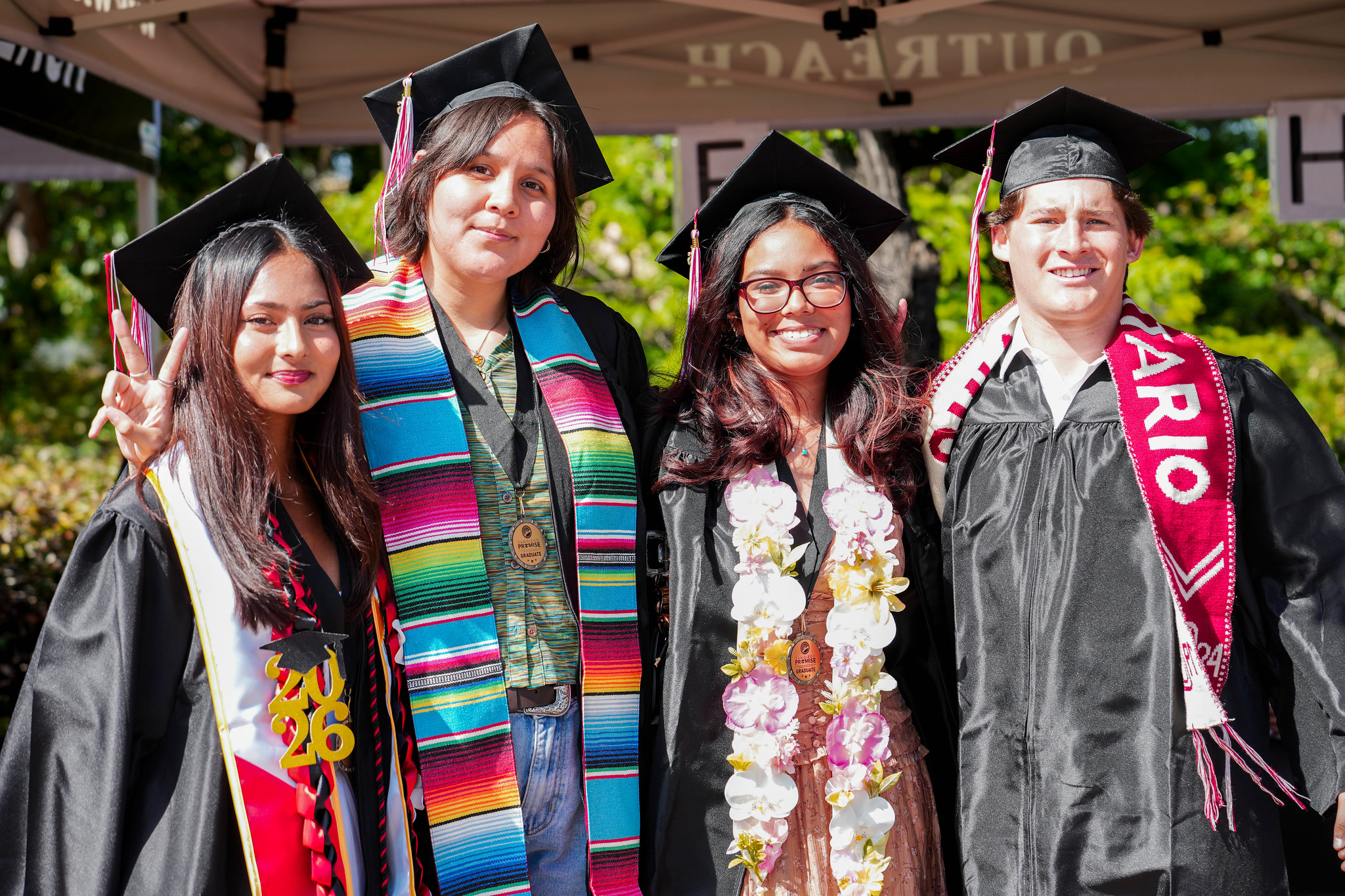 Four graduates pose together.&nbsp;