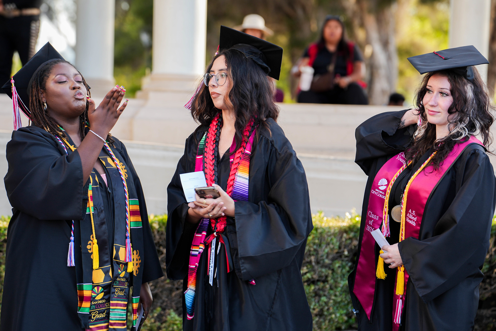 A graduate blows a kiss to the audience.