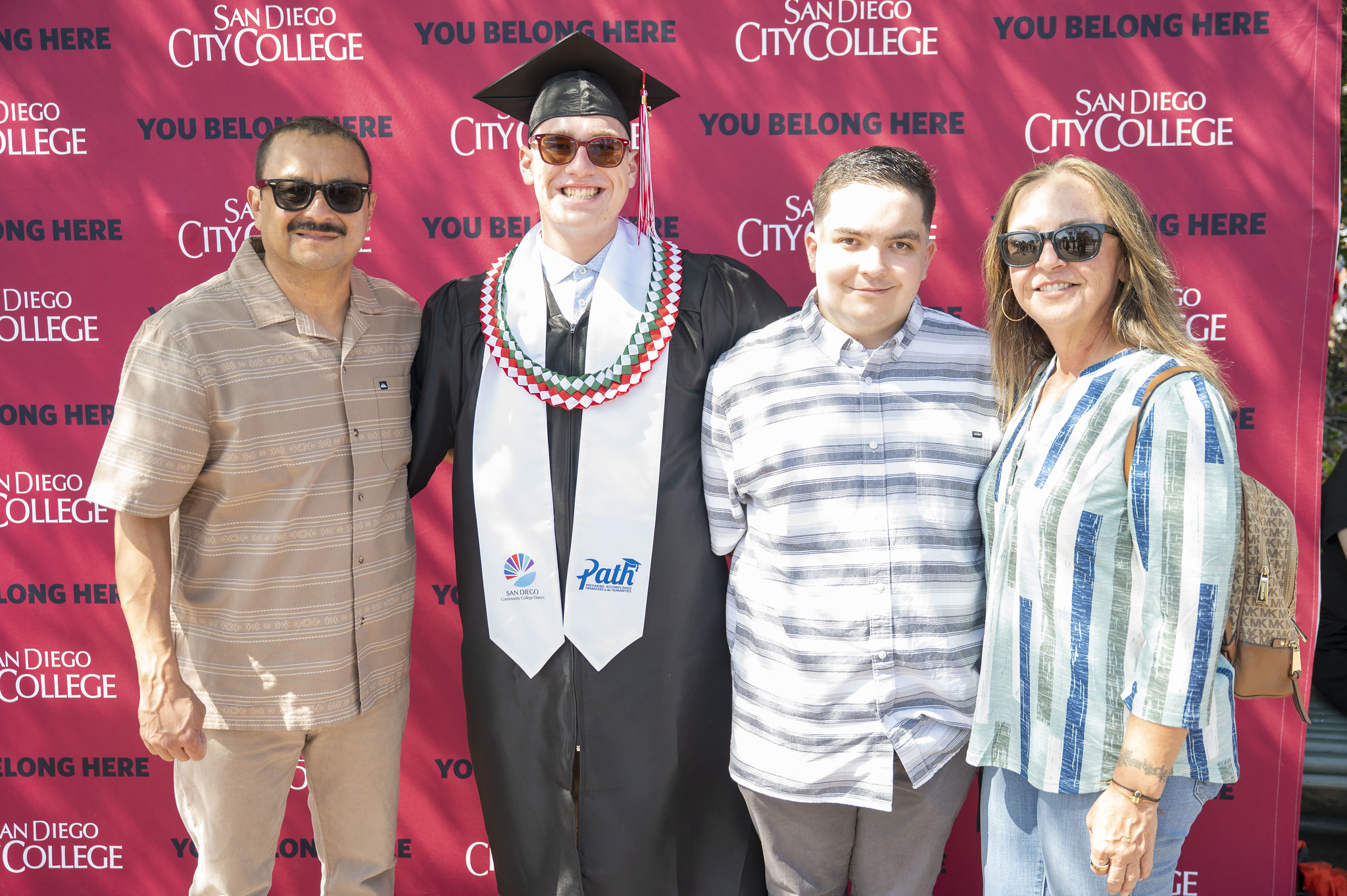A graduate poses with three family members.