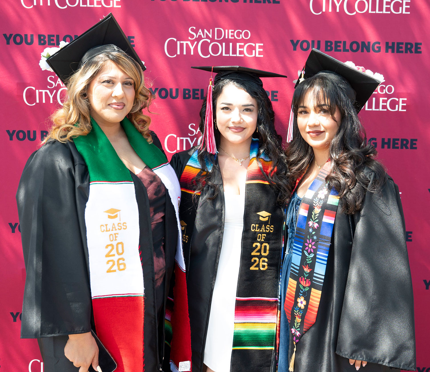 Three graduates at commencement.