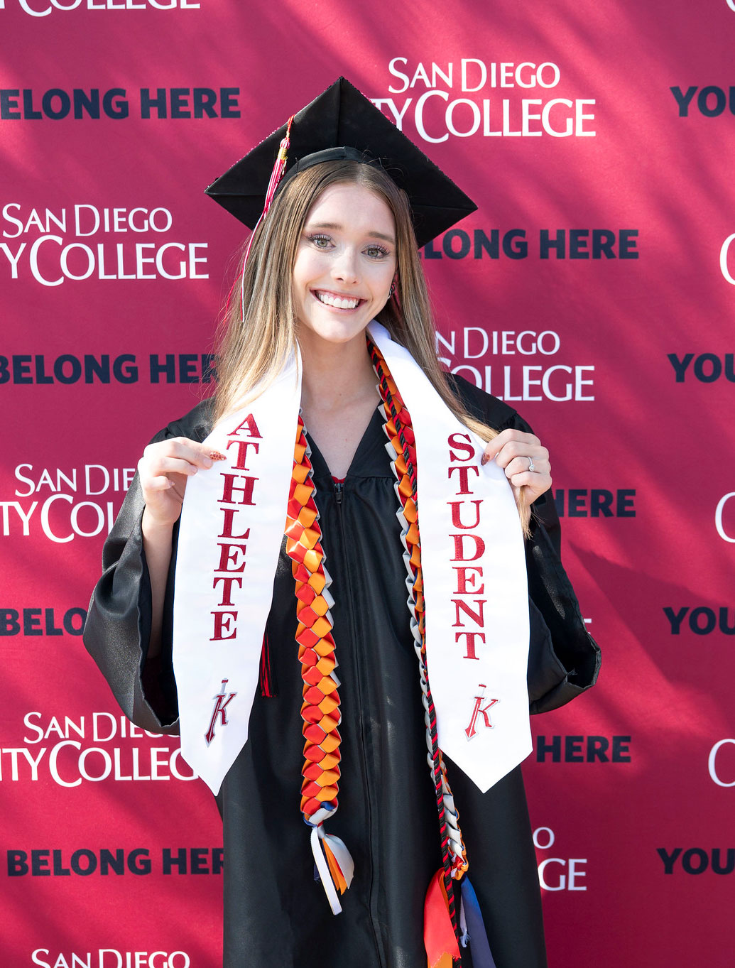A graduate holds up her Student Athlete stole.&nbsp;