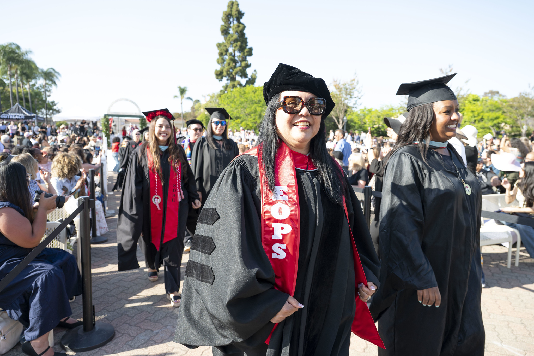 Two lines of graduates walk to their seats at the beginning of commencement.&nbsp;