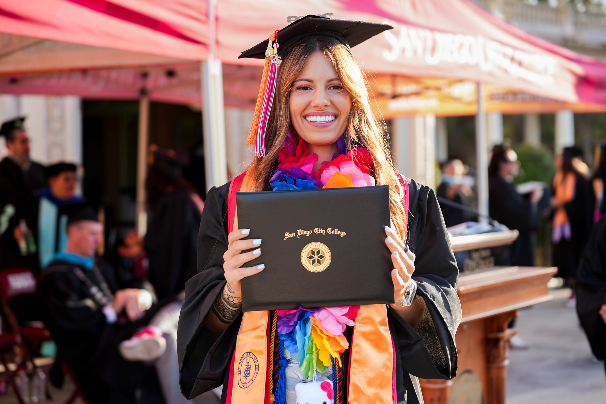 A student holds up her degree.