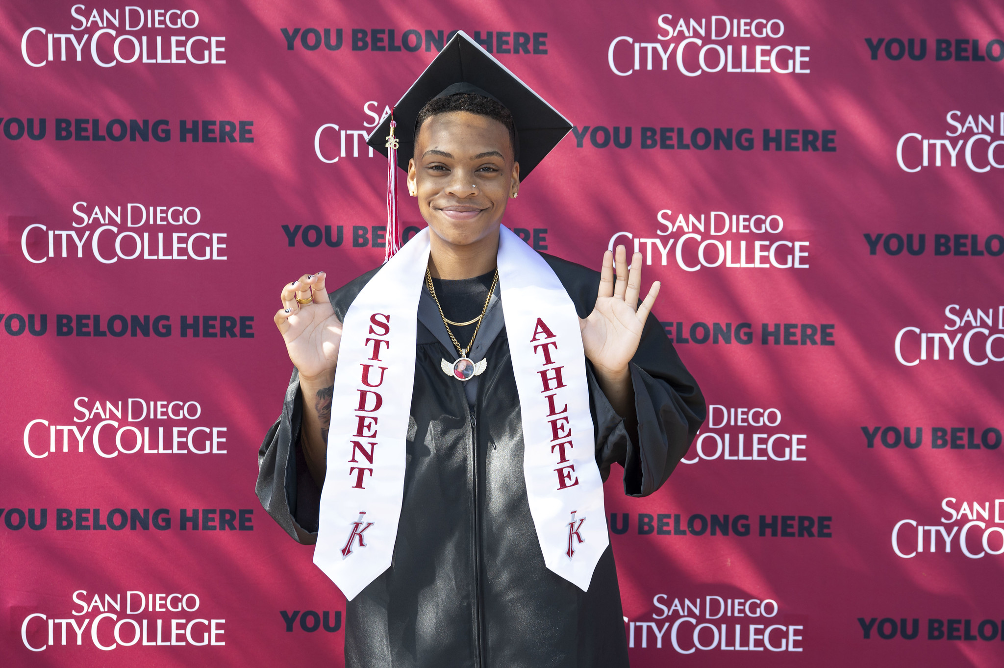 A graduate holds up his student athlete stole.&nbsp;