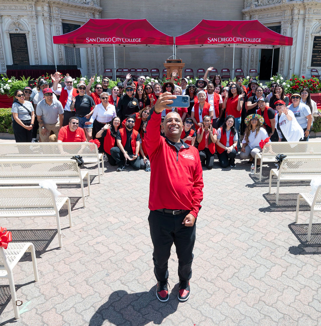 Dozens of commencement volunteers take a selfie with City College President Ricky Shabazz before the start of the ceremony.