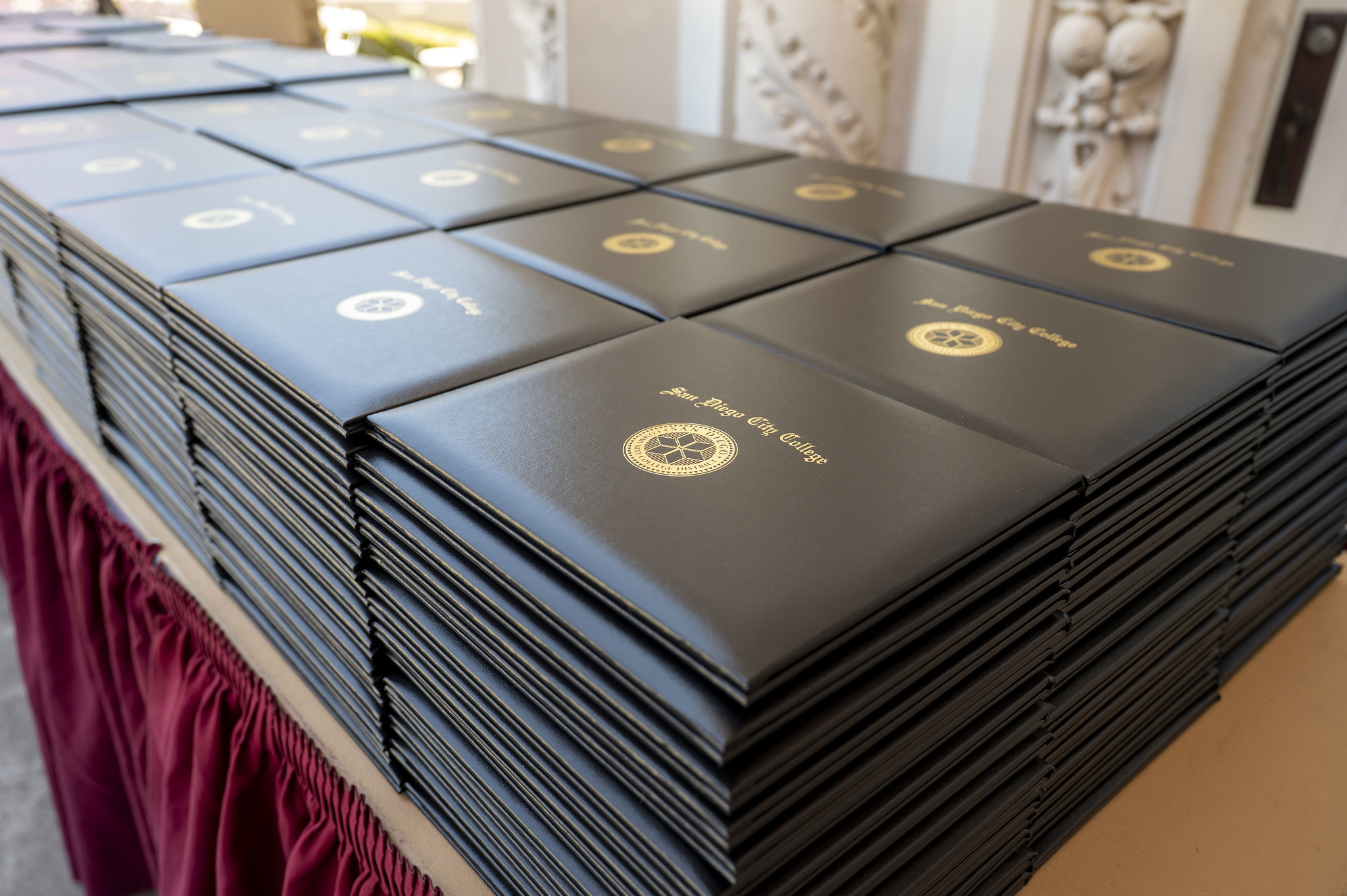 Eight stacks of degrees on a table ready to be handed out.
