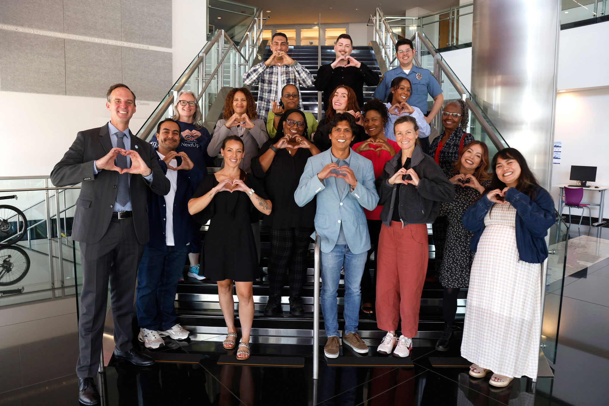 17 members of the Faculty Leadership academy take a group photo on a staircase with the chancellor.