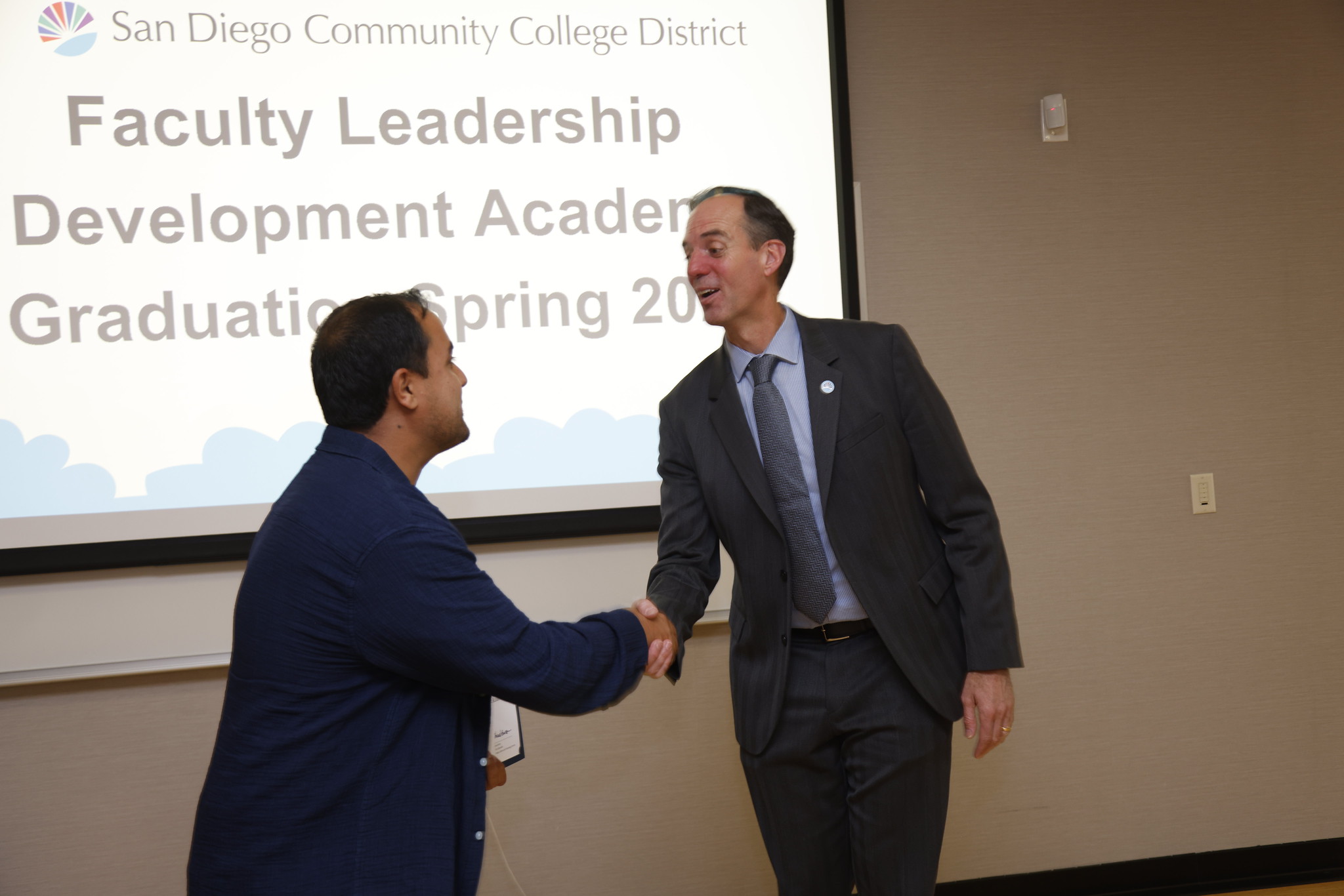 Mohammad Arif Mayar shakes the chancellor's hand.