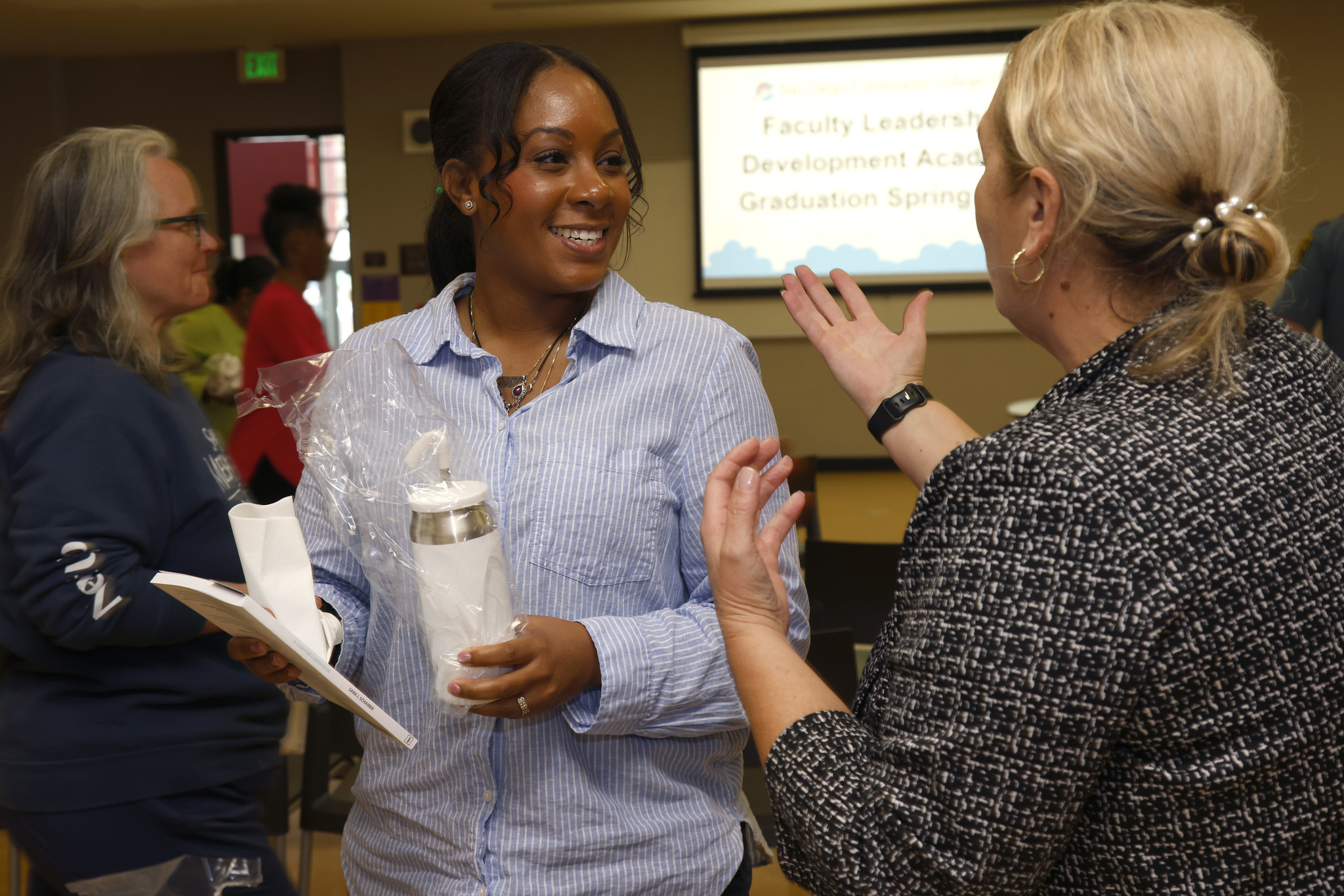 Two ladies speaking at the certificate distribution for the academy.