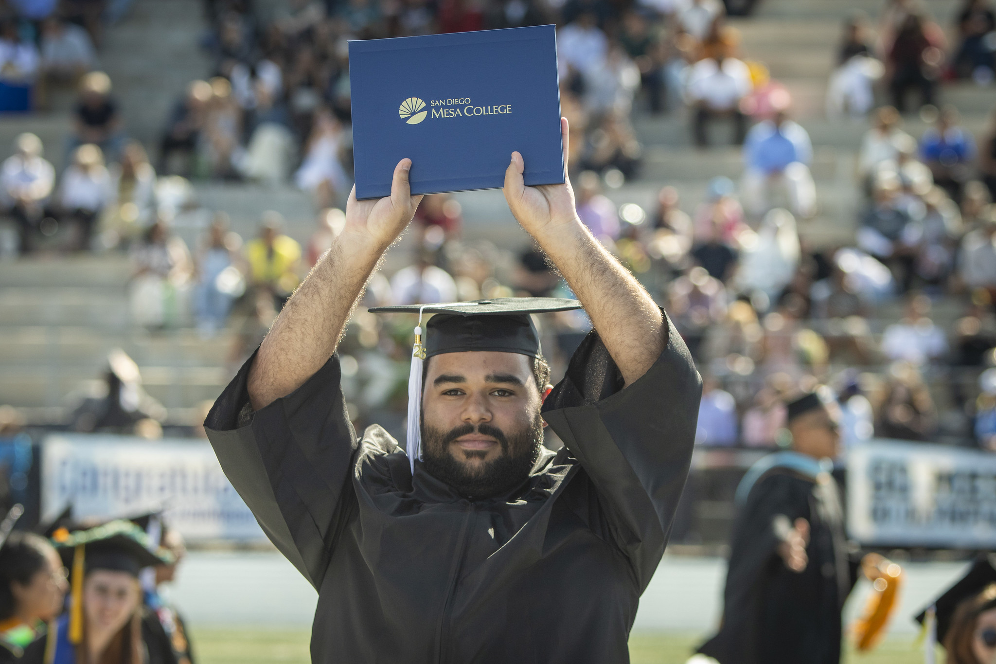 A grad holds his degree over his head.&nbsp;
