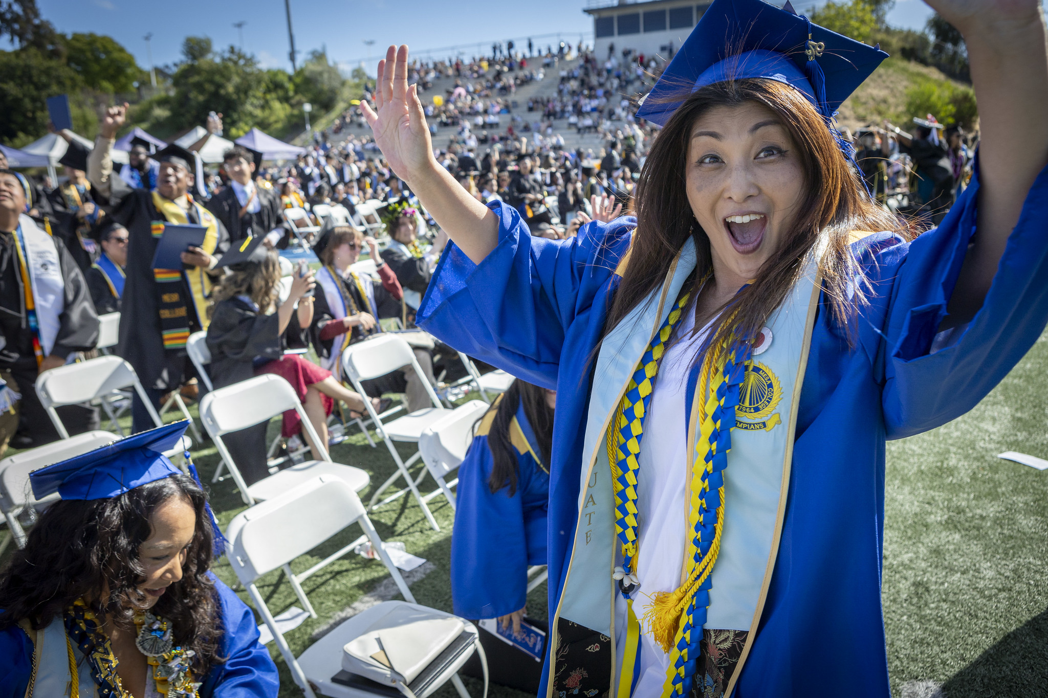 A grad cheers as she waits in line to get her degree.&nbsp;
