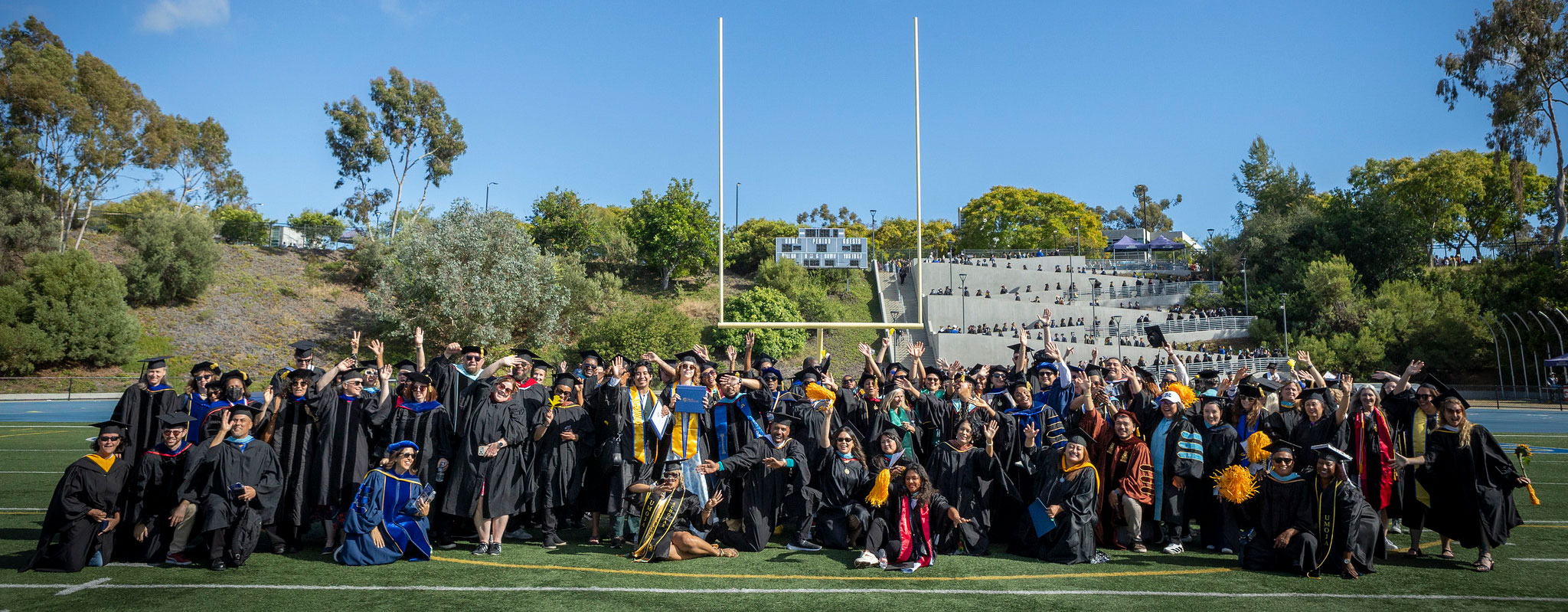 A group photo of about 100 faculty in the graduation caps and gowns.
