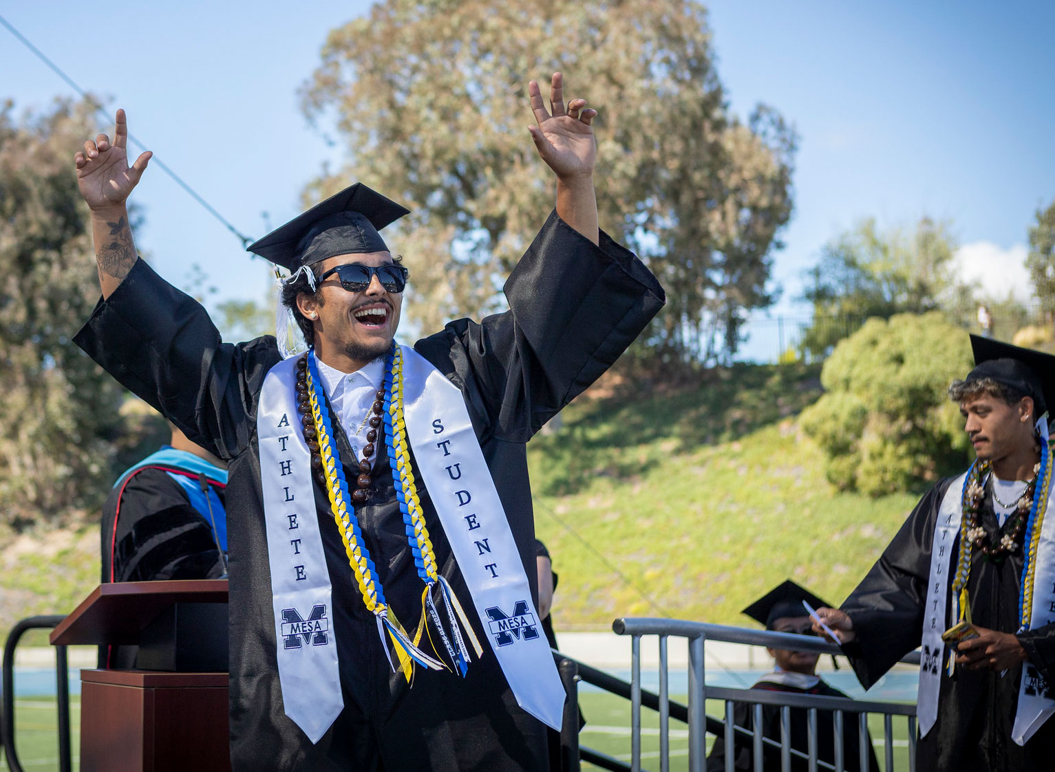 A graduate cheers on stage.