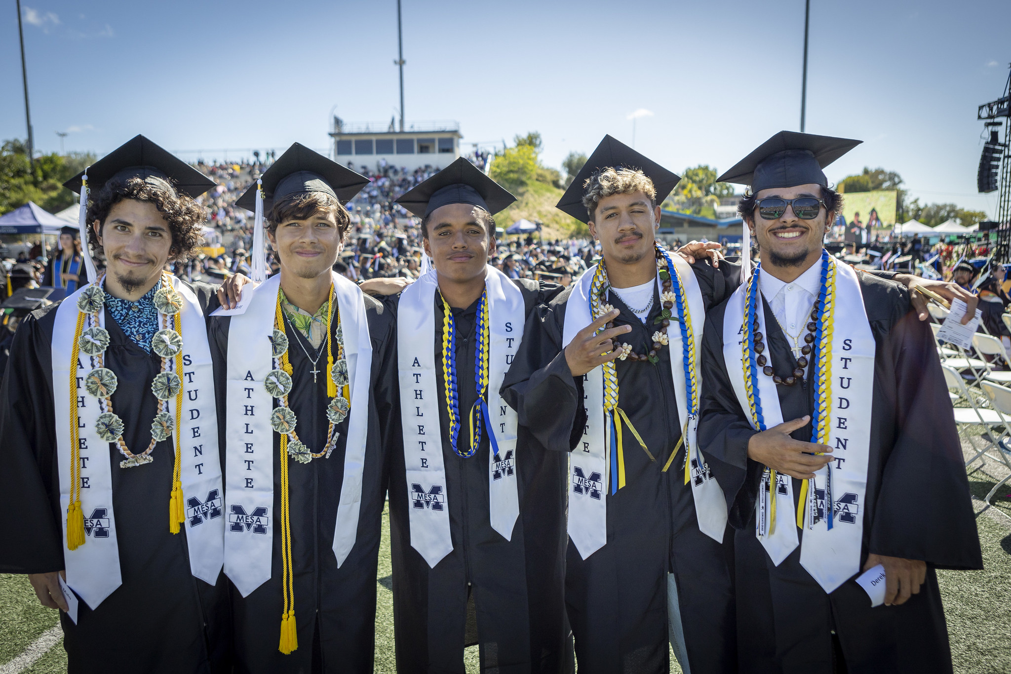 Five students in caps and gowns with Student Athlete stoles.