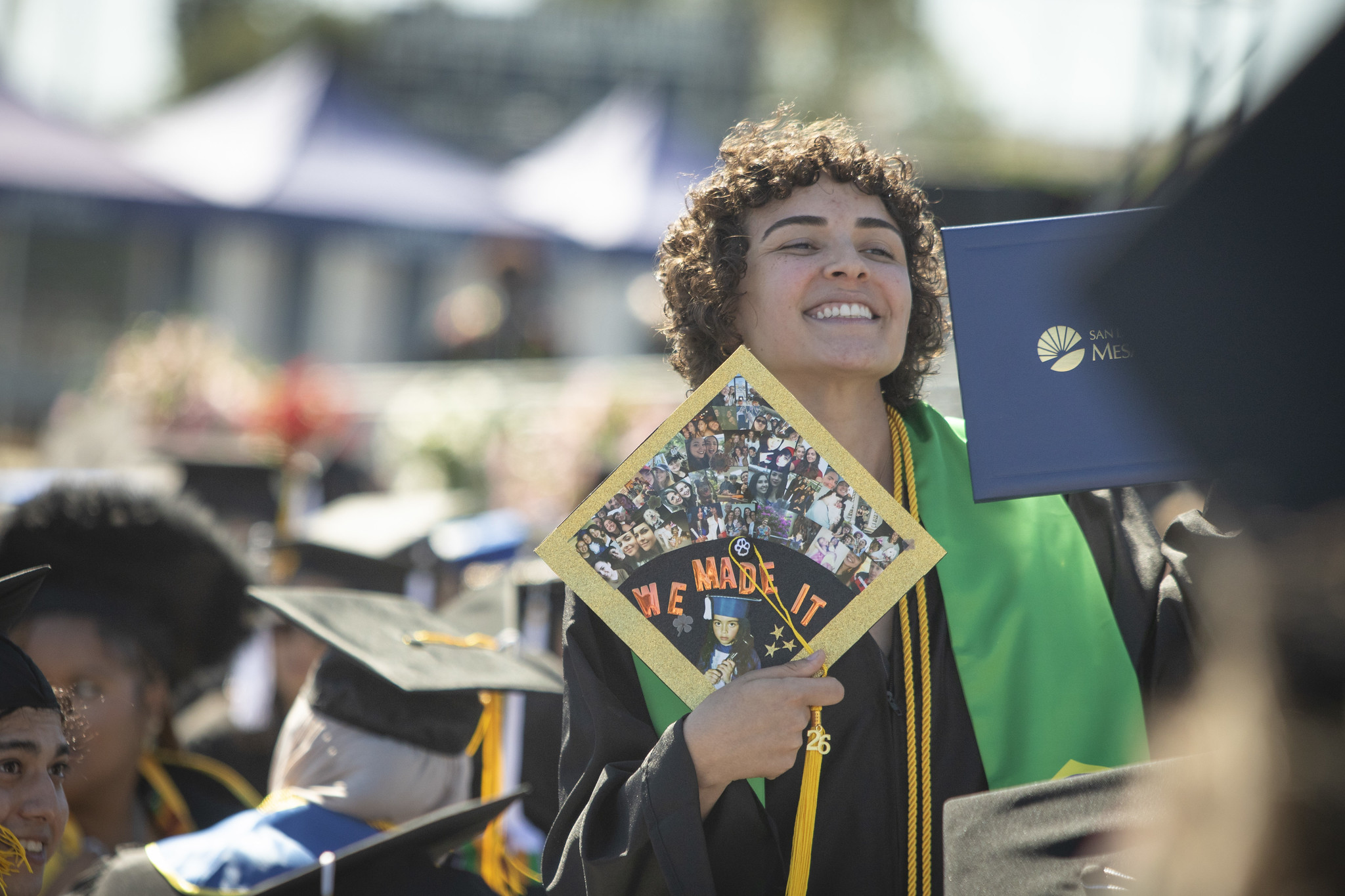 A grad holds up their cap that says we made it.