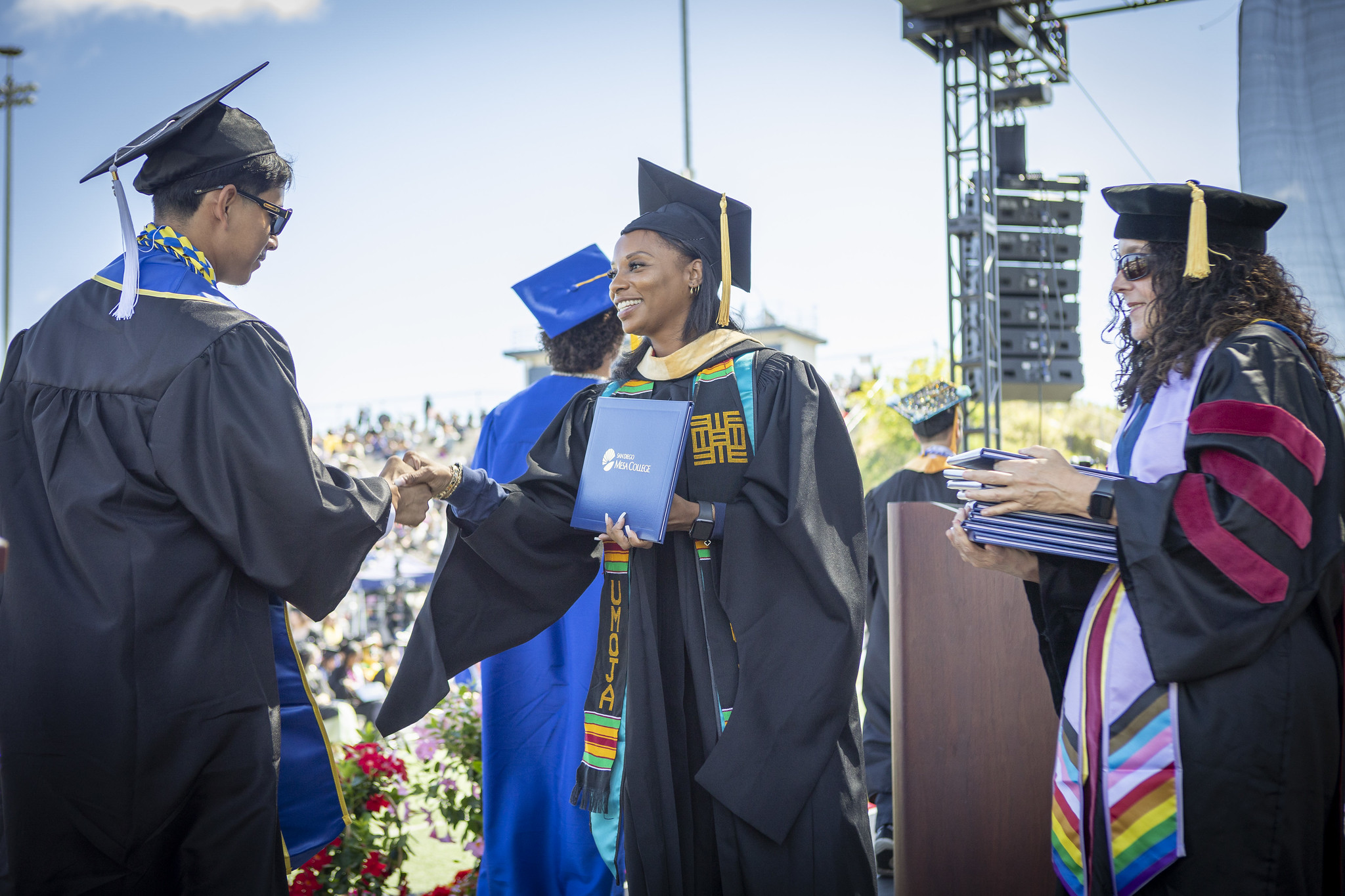 Trustee Mariah Jameson gives a student his degree.&nbsp;