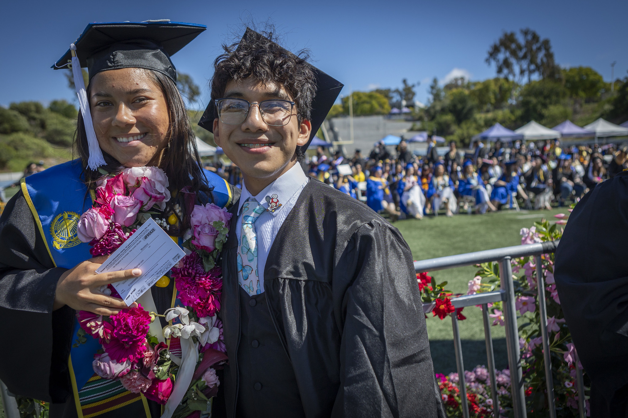 Two grads waiting in line for their degrees.