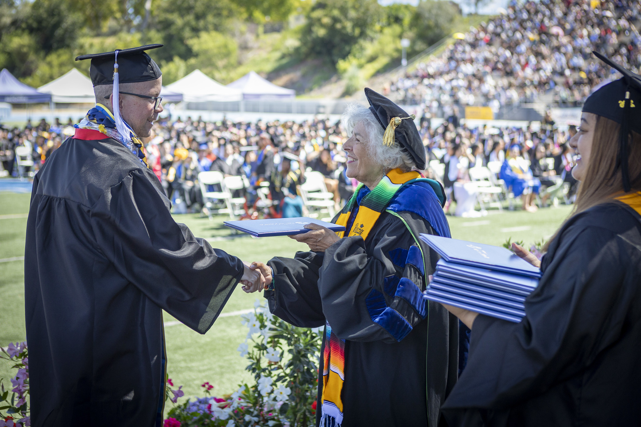 Trustee Maria Nieto Senour give a student their degree.&nbsp;