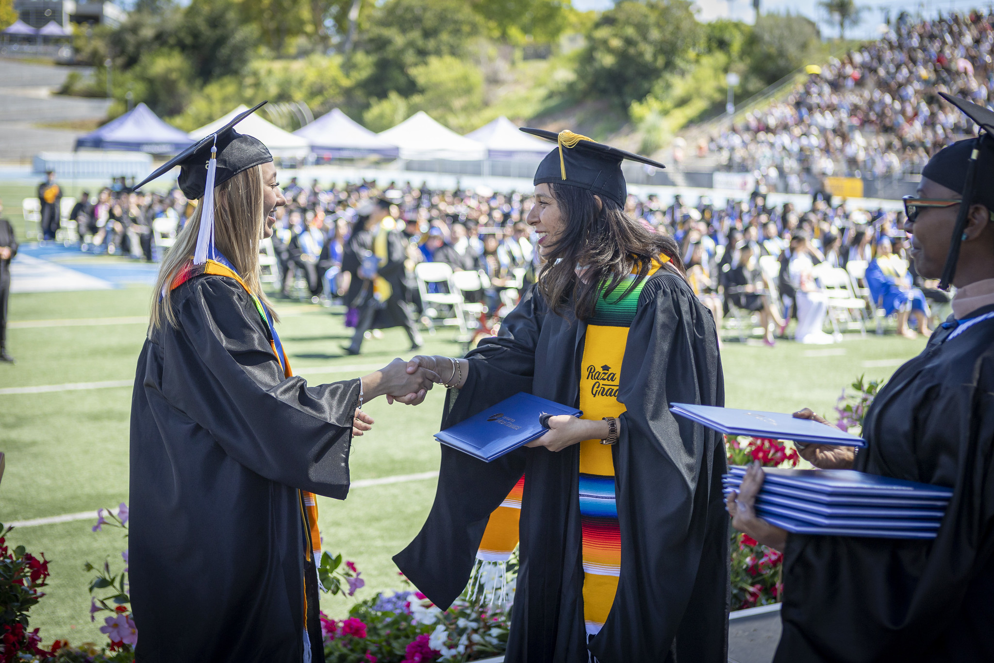 Trustee Geysil Arroyo gives a student their degree.&nbsp;