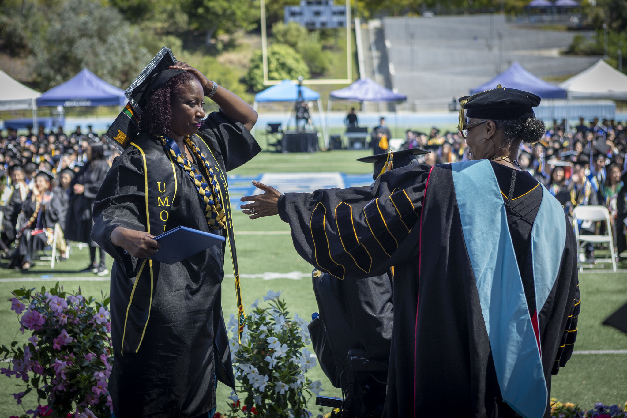Mesa President Ashanti Hands with a student on stage.