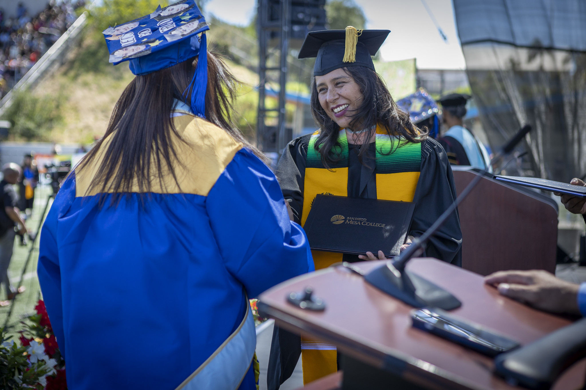 Trustee Geysil Arroyo gives a student their degree.&nbsp;