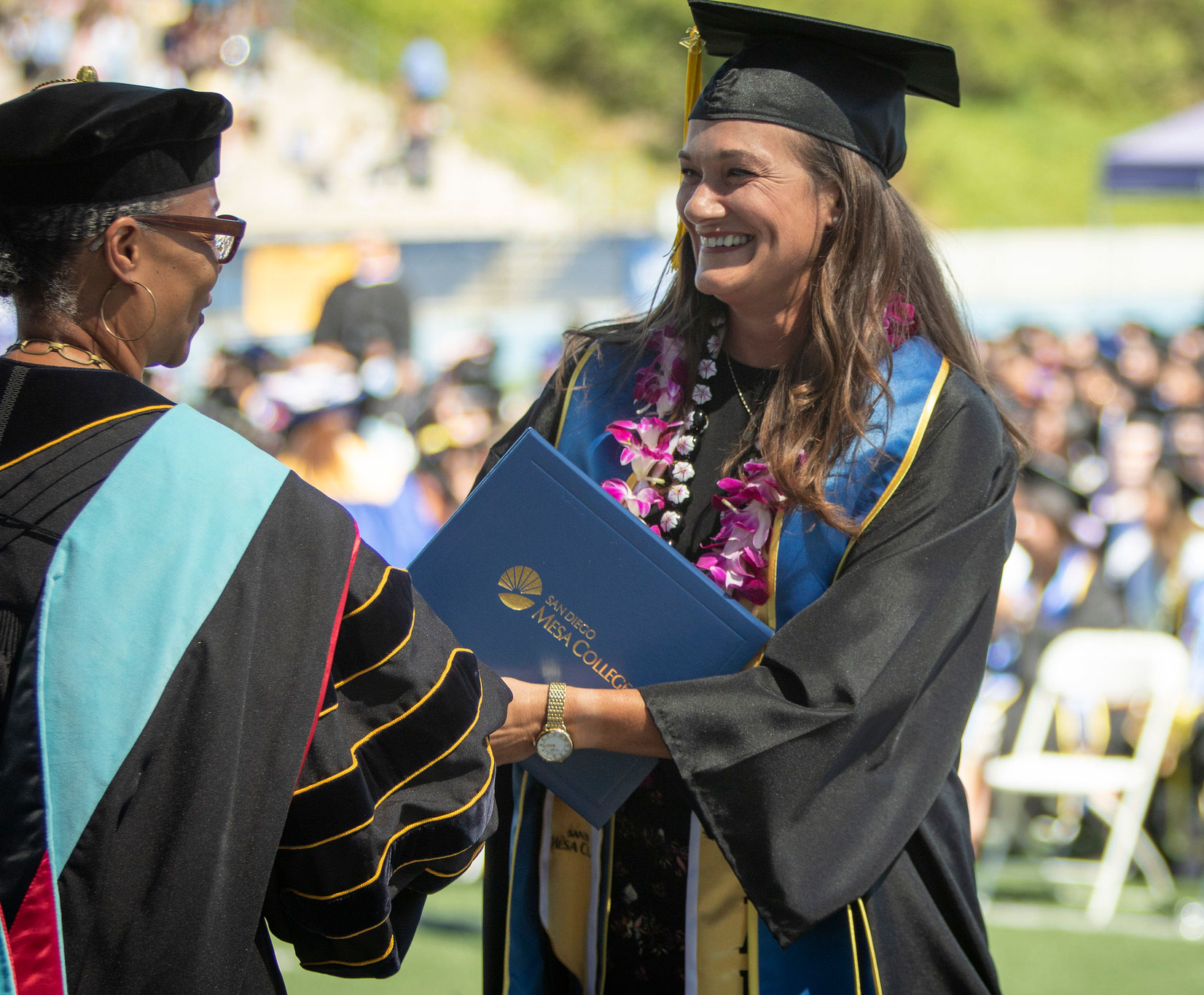 Mesa President Ashanti Hands shakes a graduates hand.&nbsp;