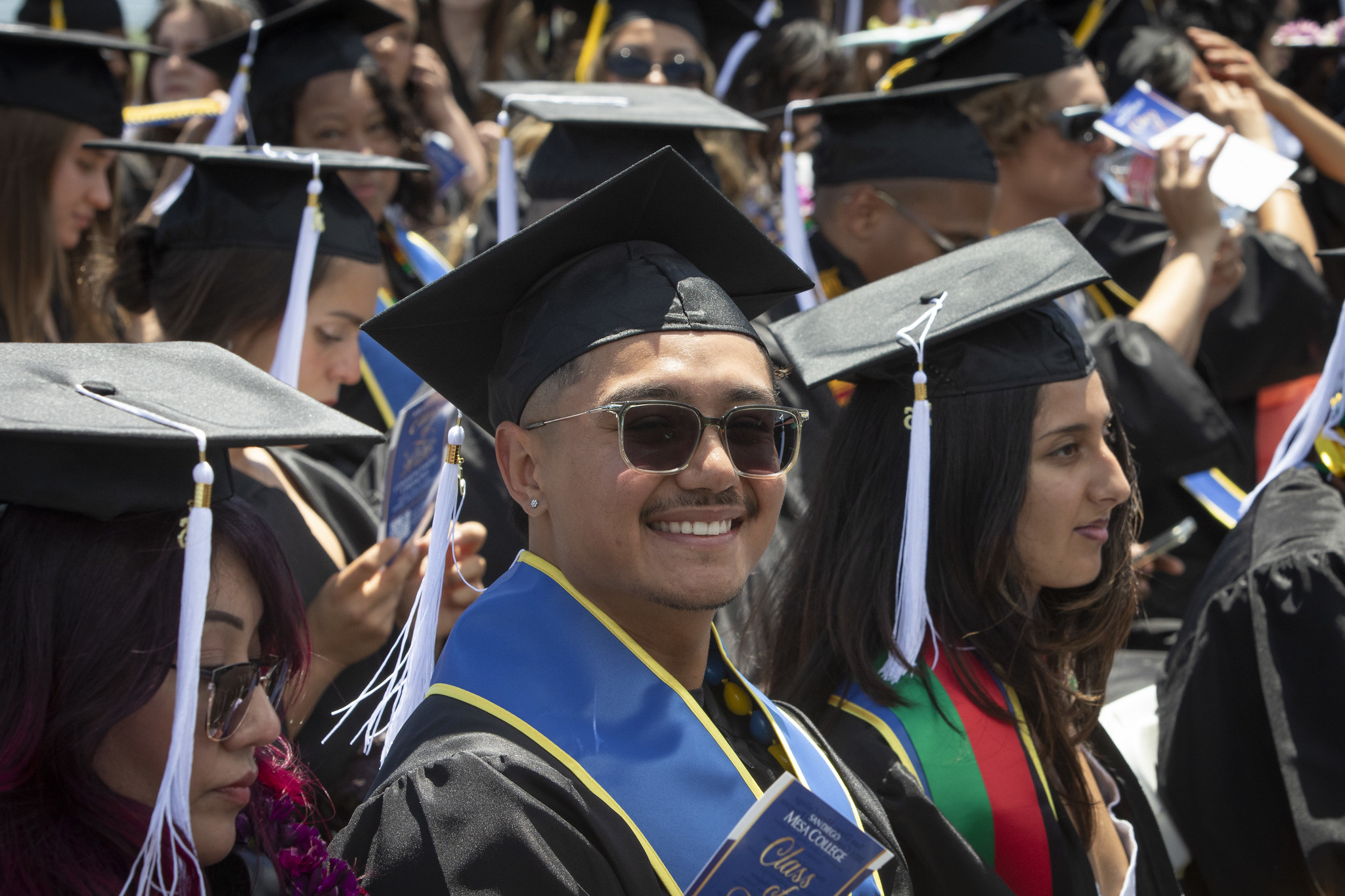 A grad in sunglasses seated in the audience.