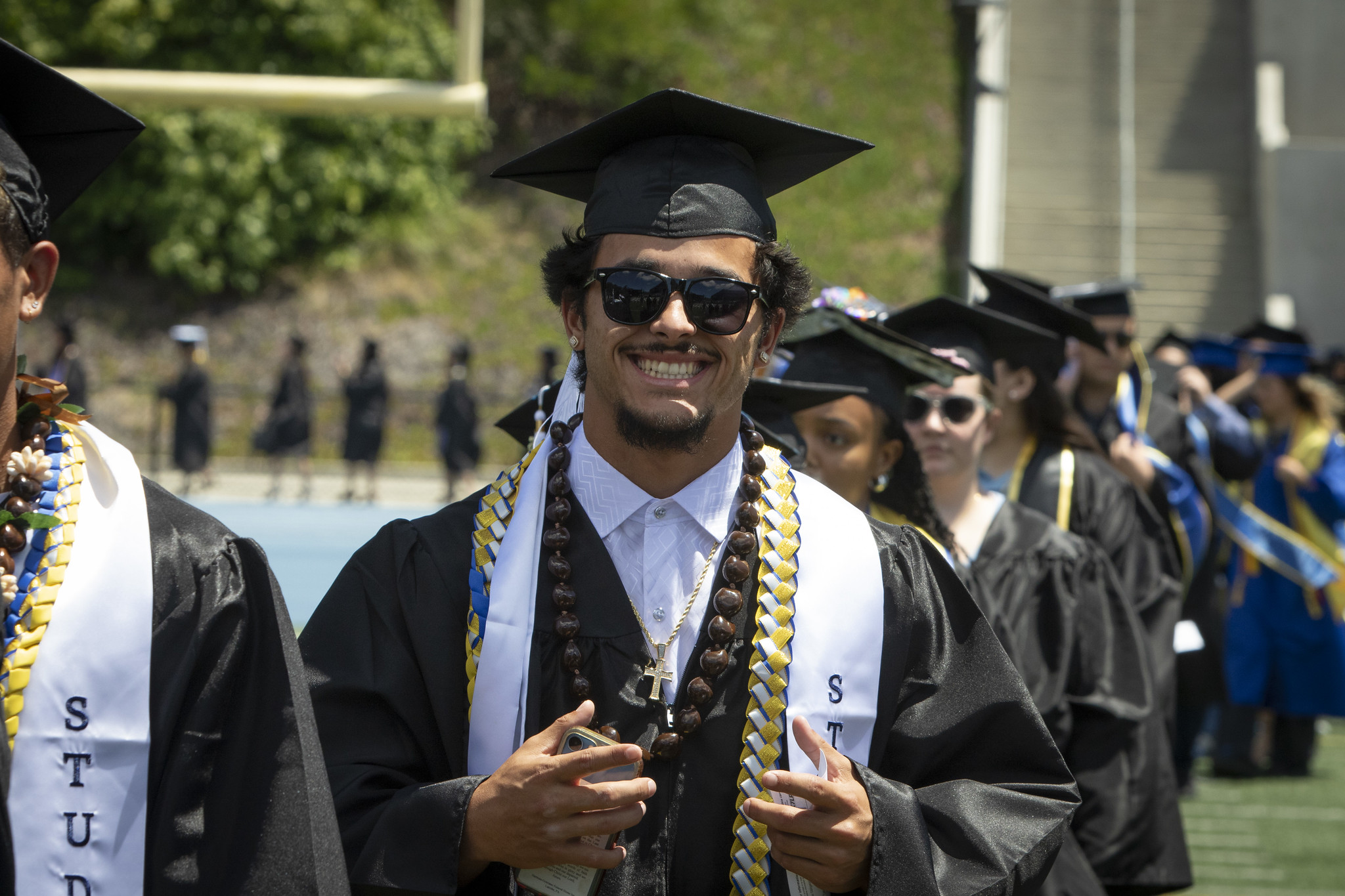 Graduates walking on the field to their seats at the start of the ceremony.