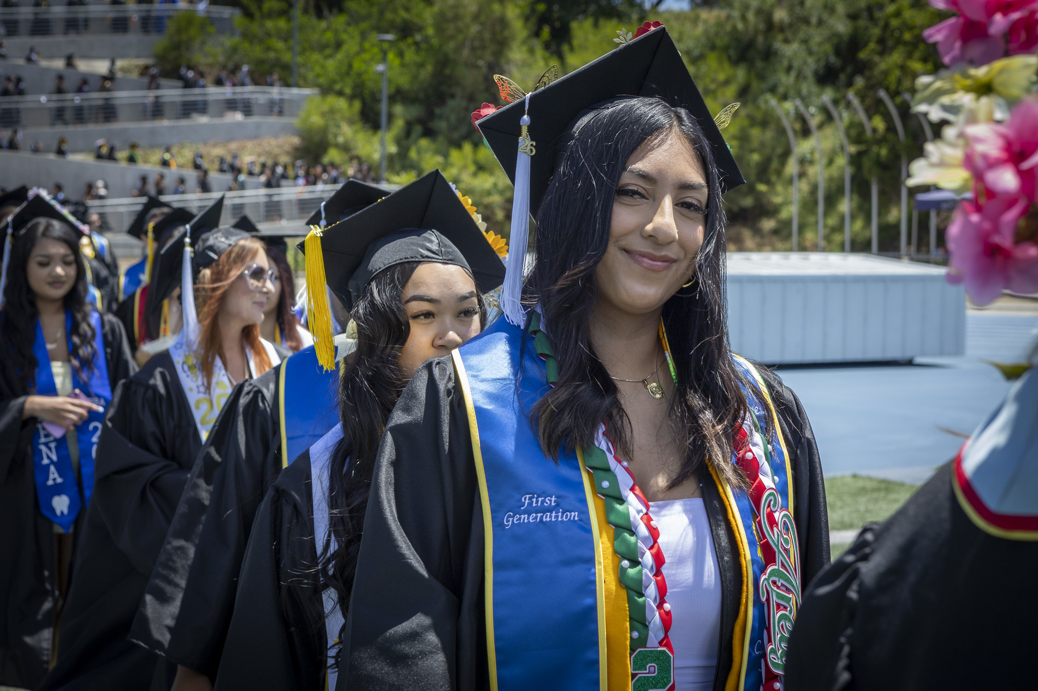 Graduates walking on the field to their seats at the start of the ceremony.