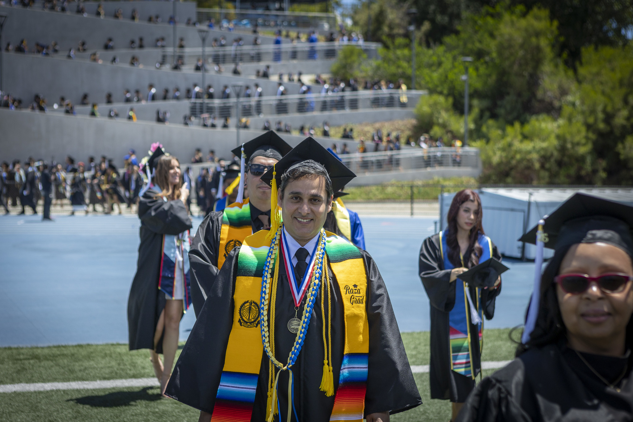 Graduates walking on the field to their seats at the start of the ceremony.