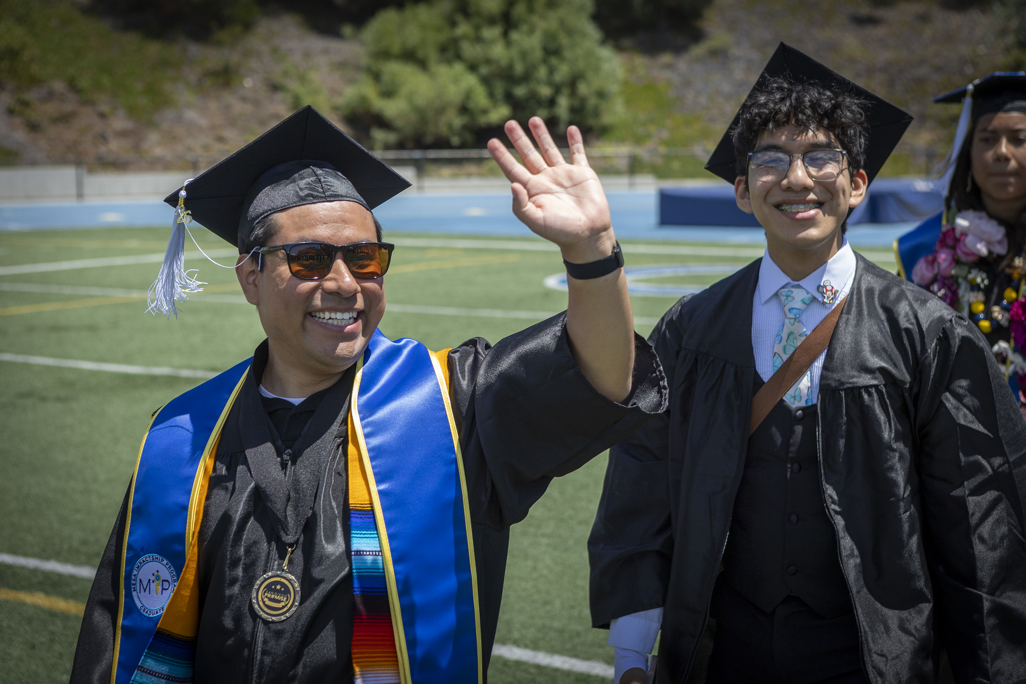 Graduates walking on the field to their seats at the start of the ceremony.