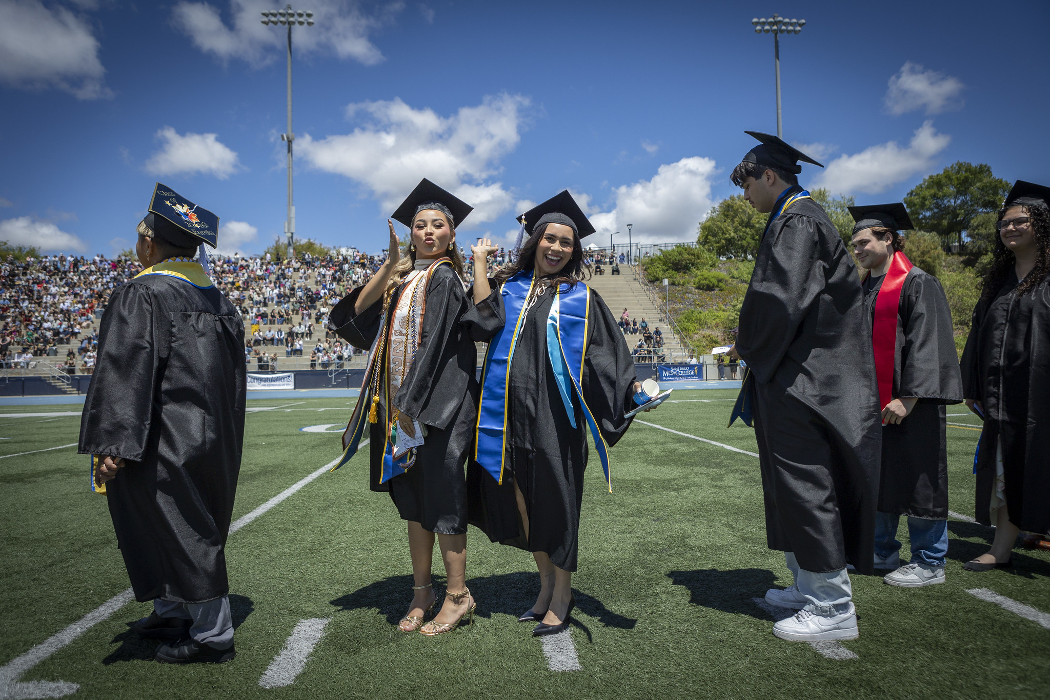Graduates walking on the field to their seats at the start of the ceremony.