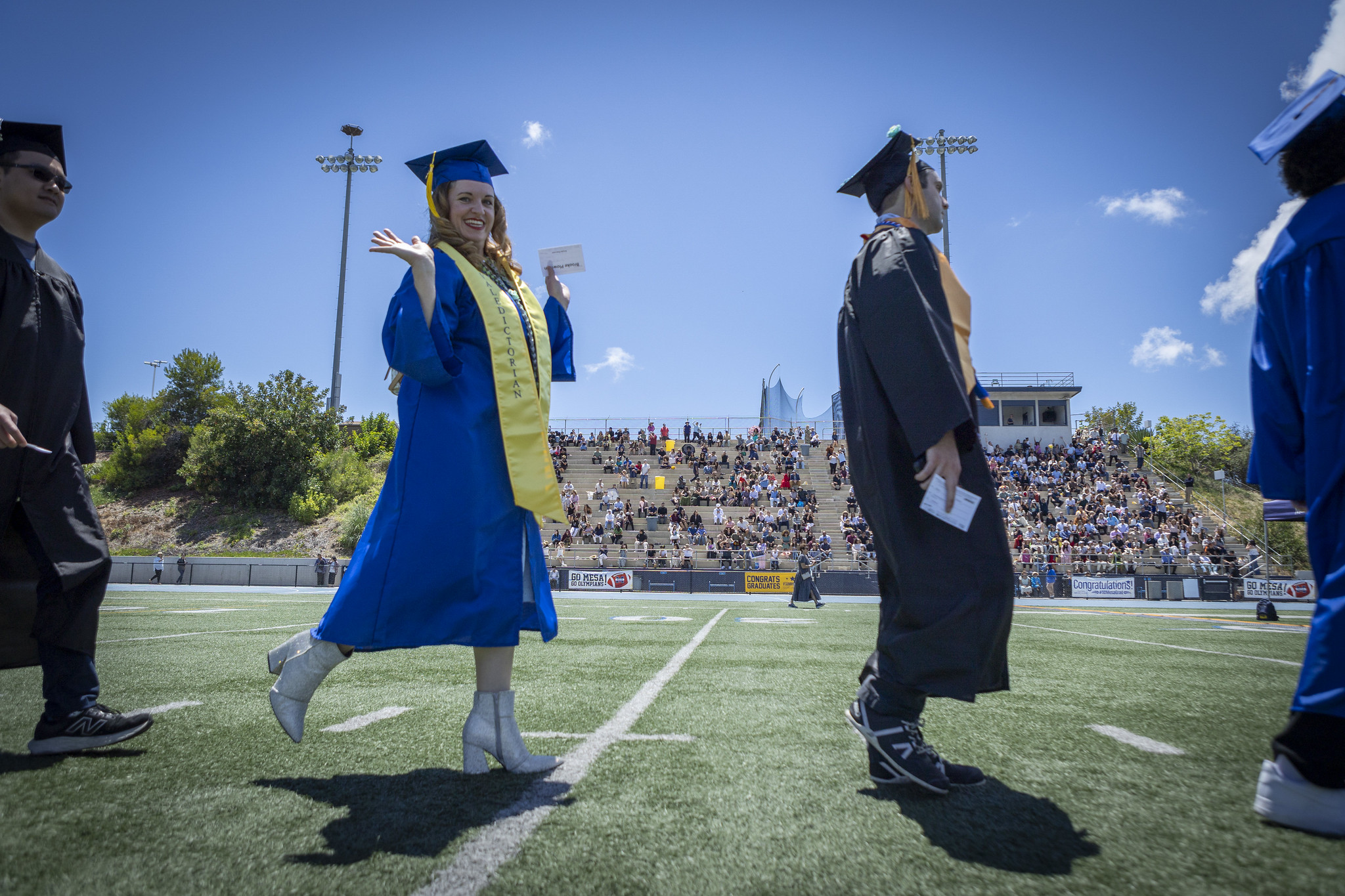 Graduates walking on the field to their seats at the start of the ceremony.