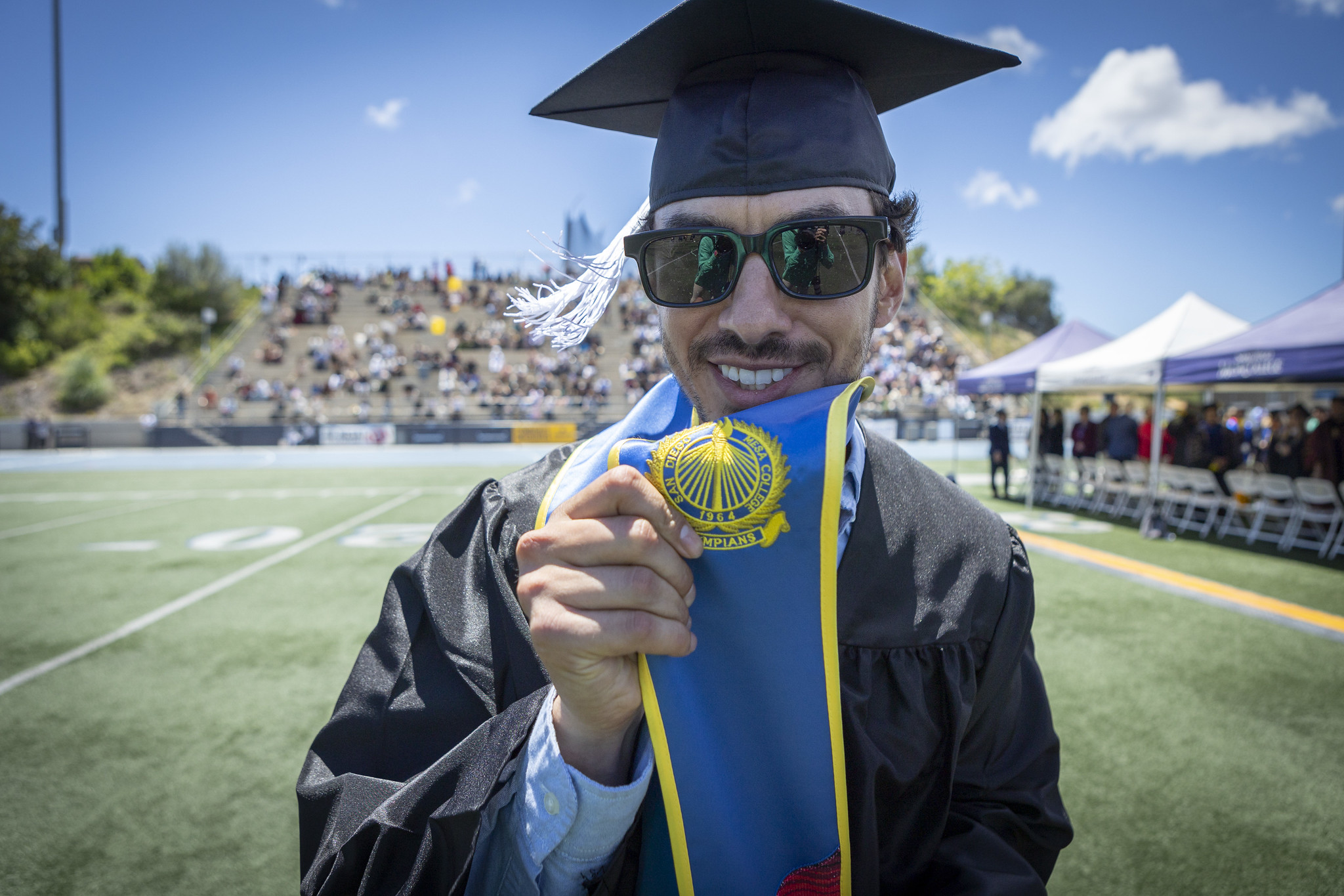A grad holds up the honors seal on his stole.&nbsp;