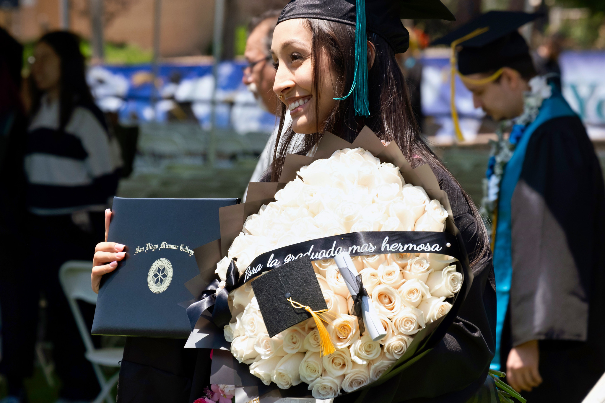 A student holds up their degree.