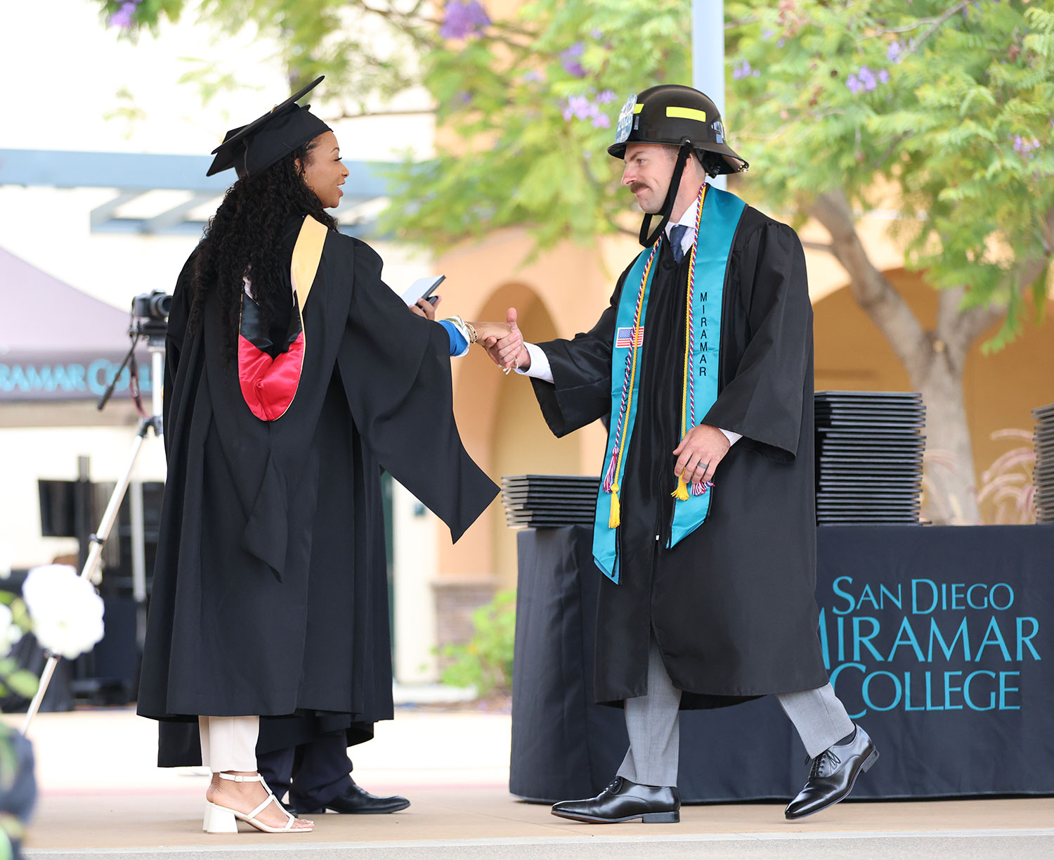A graduate from the fire academy receives his degree.&nbsp;