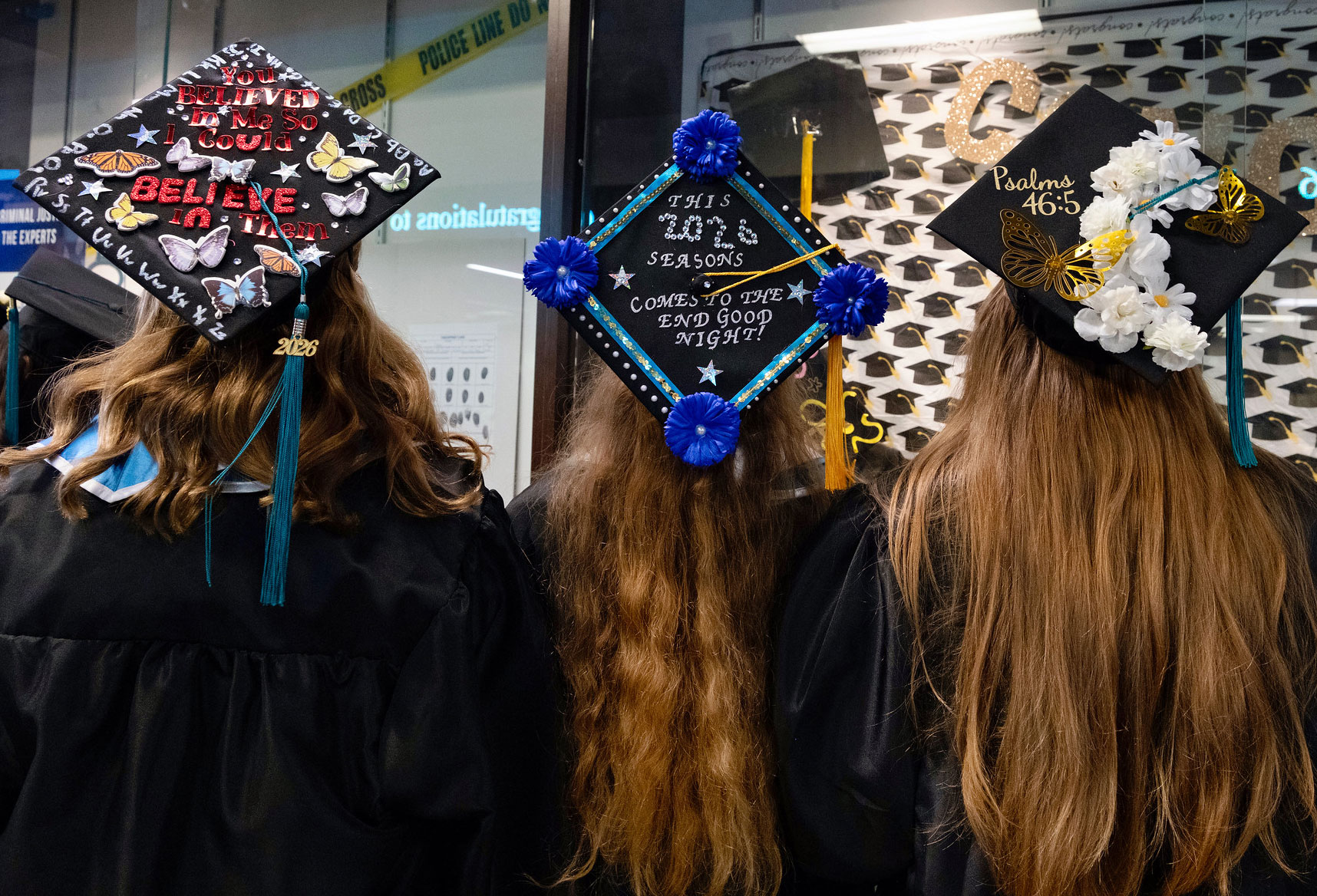 Three grads show off their cap designs.