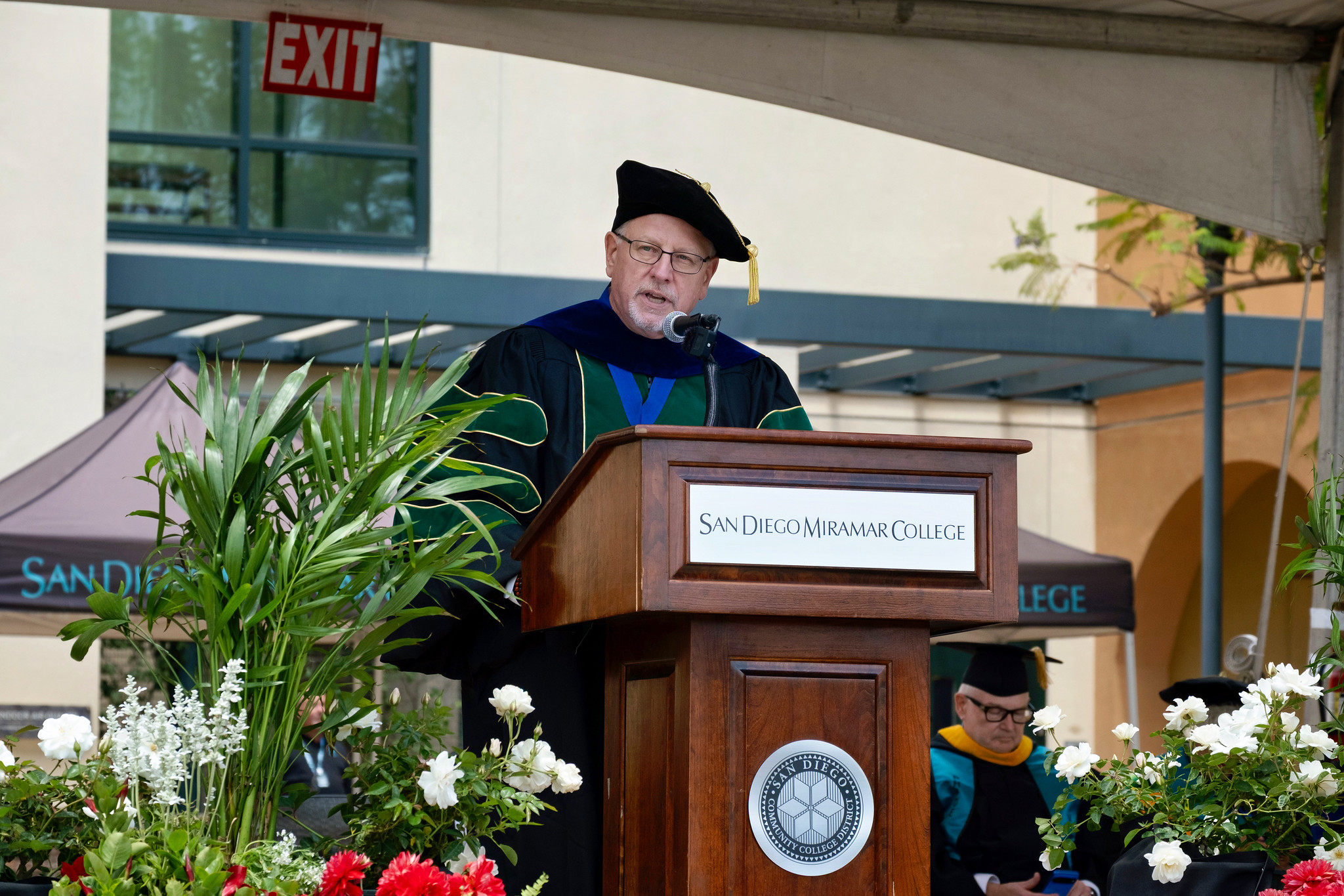 Miramar College President Wes Lundburg speaks at a podium.