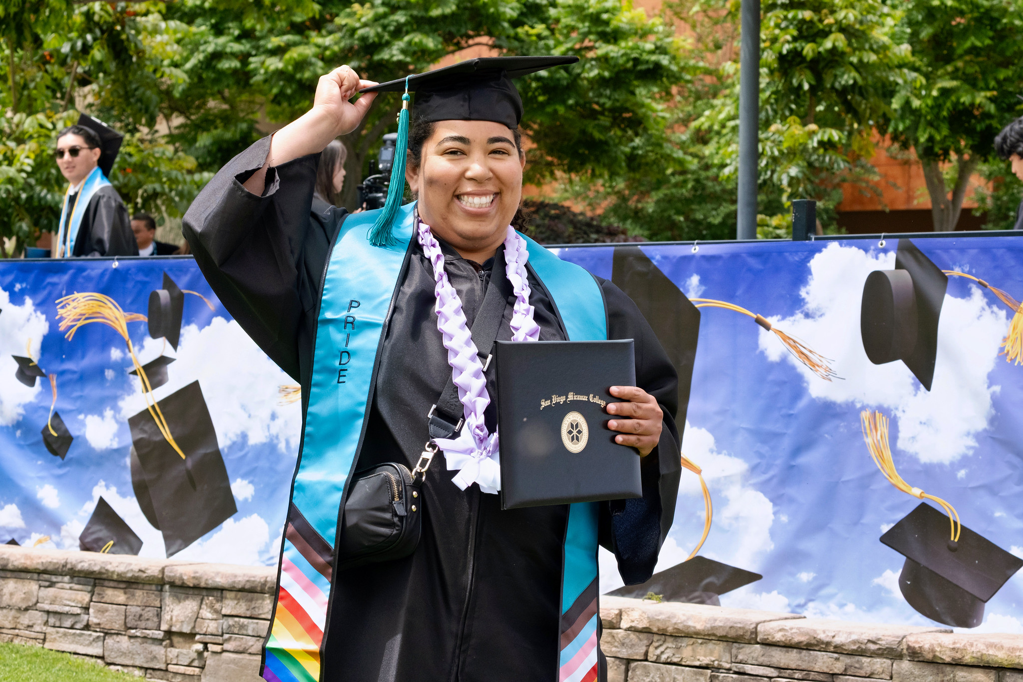 A student holds up her degree.