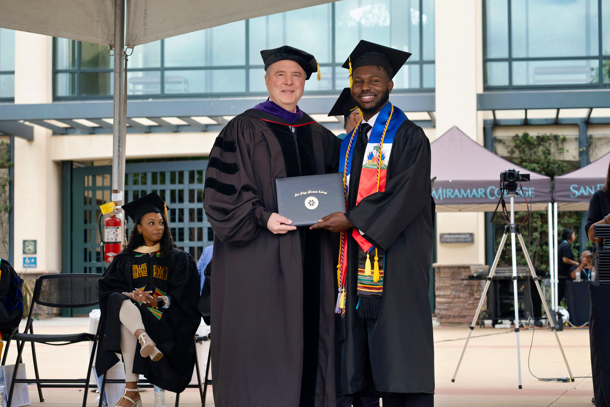 U.S. Senator Adam Schiff hands a graduate his degree.&nbsp;