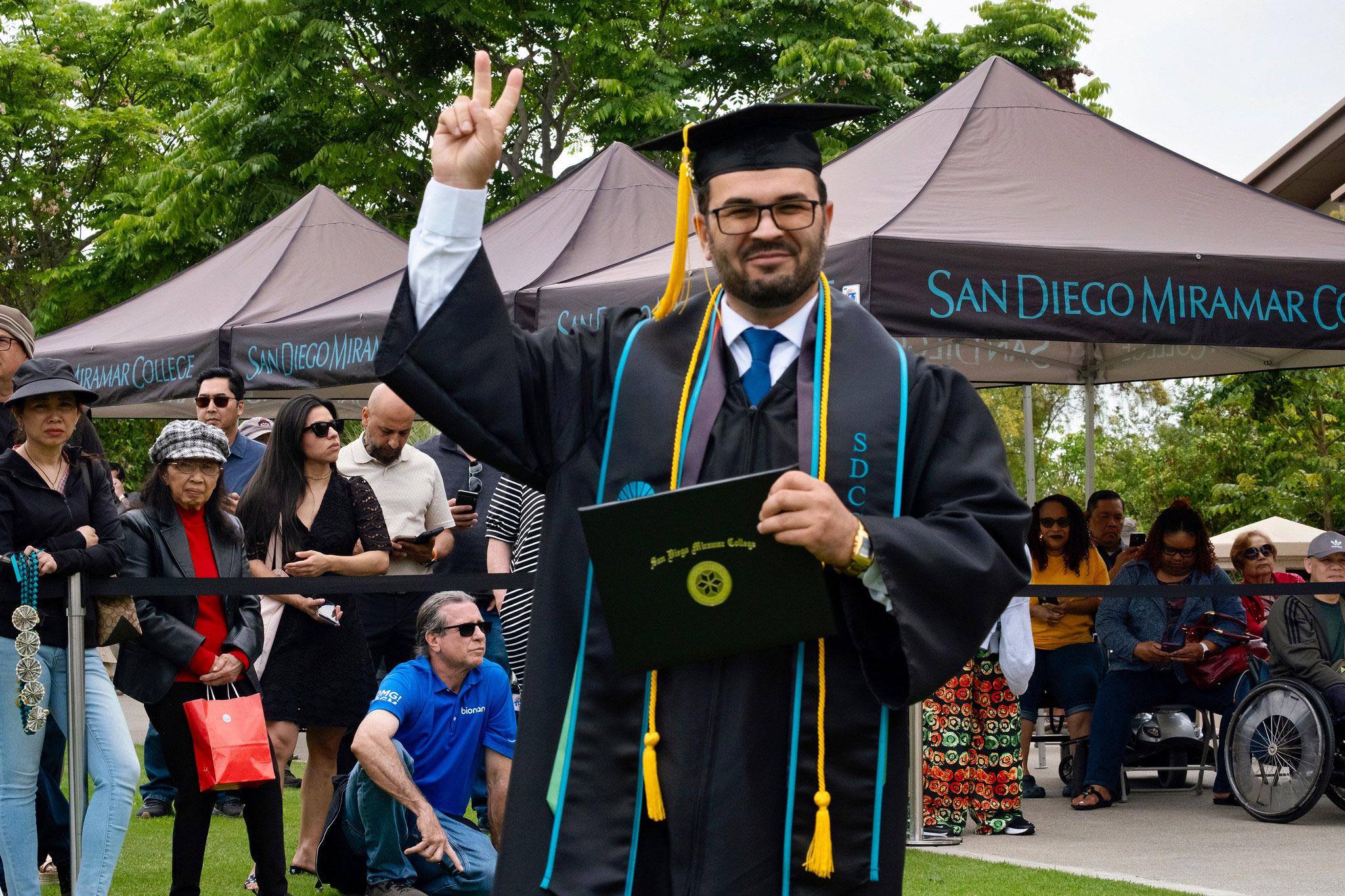 A student holds up their degree.