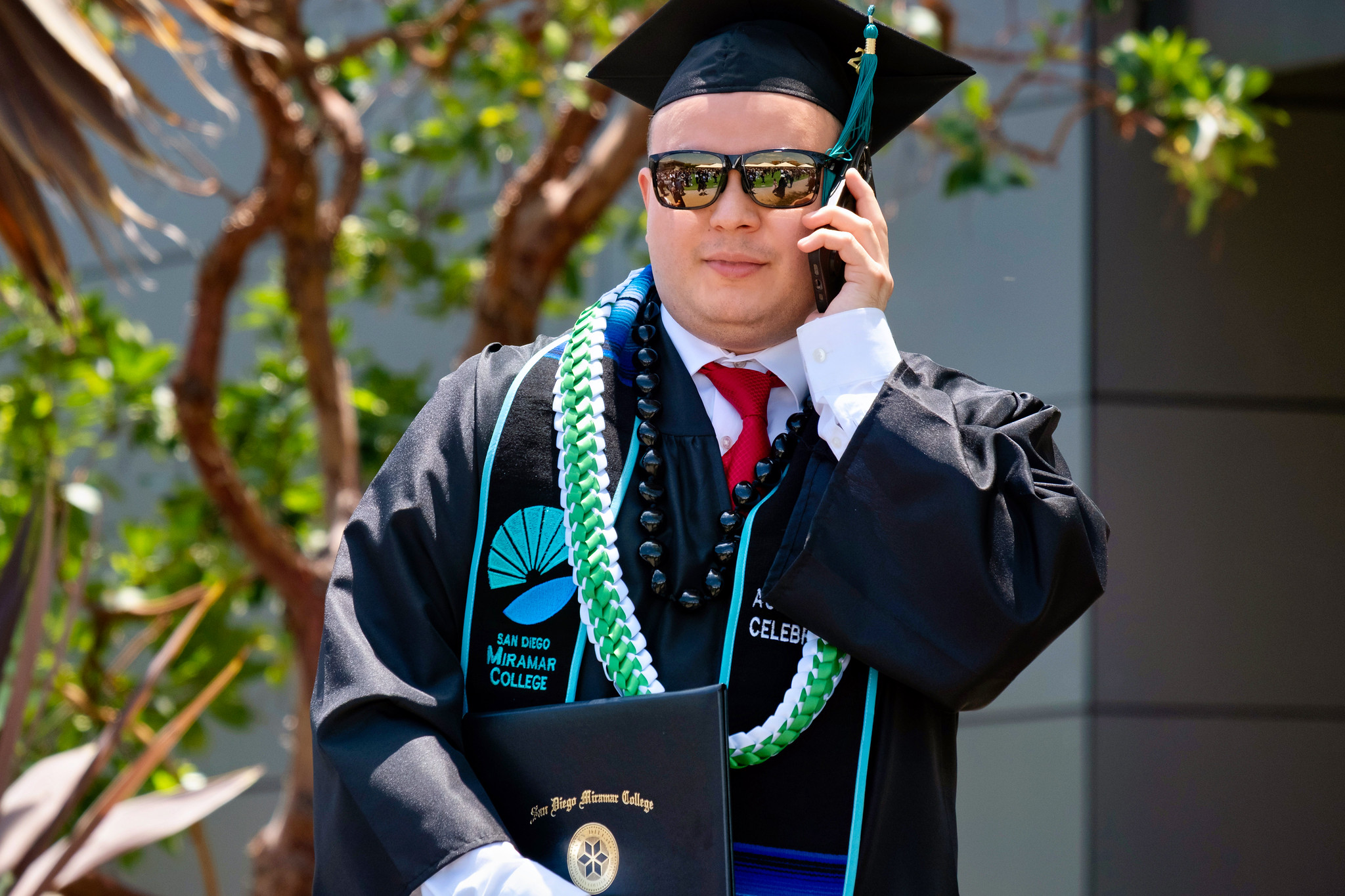 A graduate talking on his cell phone after receiving his degree.&nbsp;