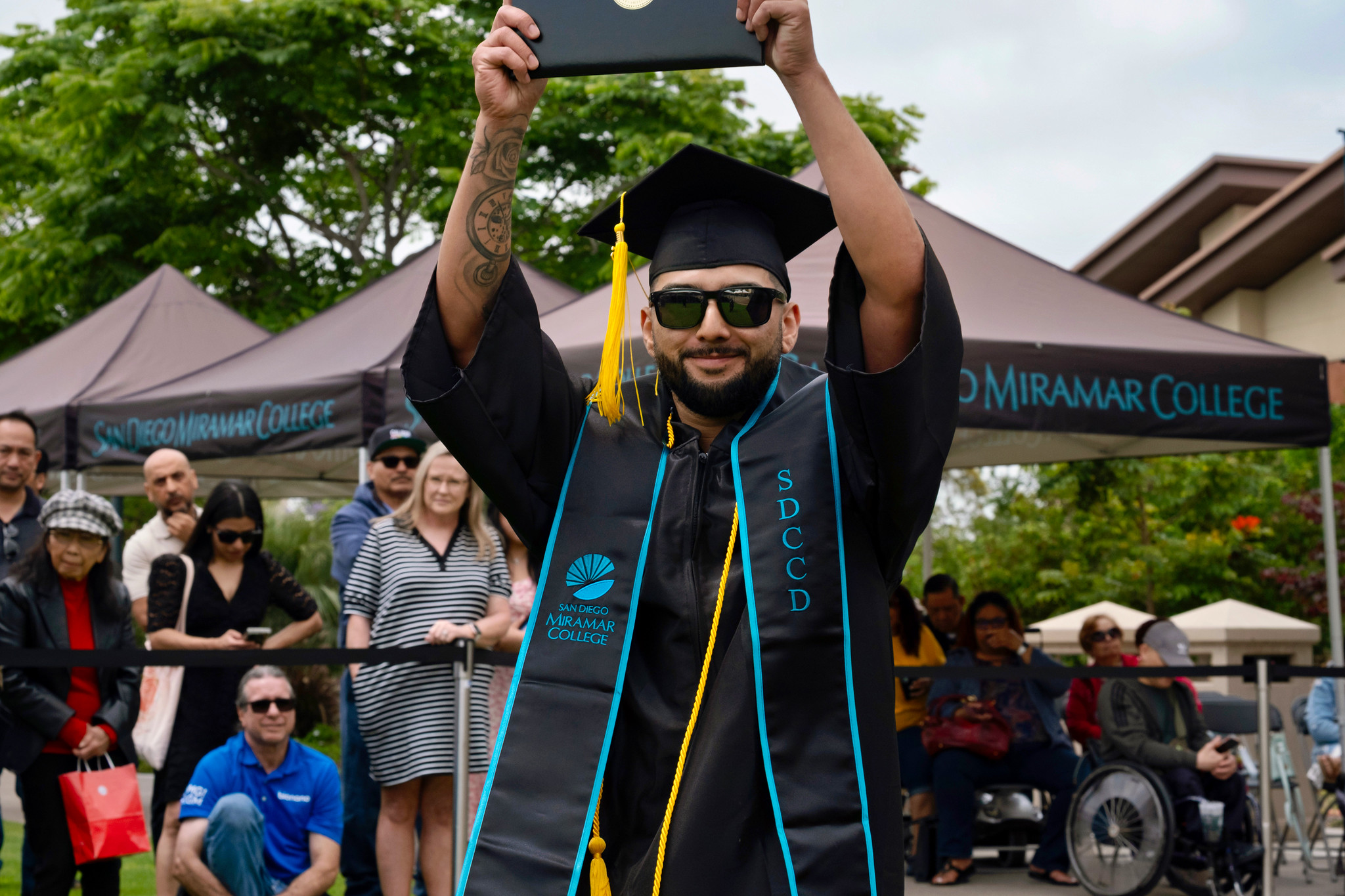 A student holds up their degree.