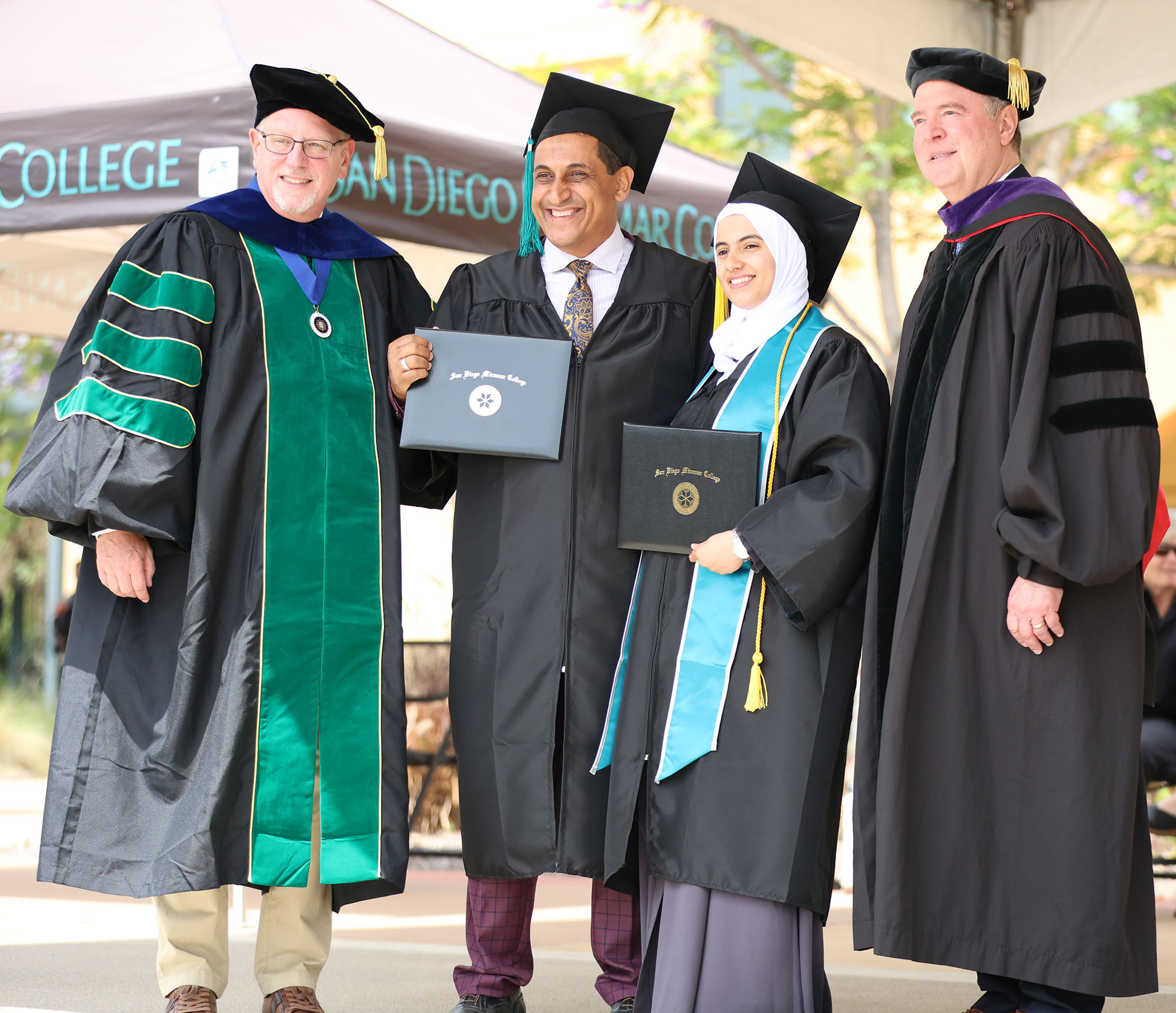 A father and daughter who graduated together pose with Miramar President Wes Lundburg and U.S. Senator Adam Schiff.&nbsp;